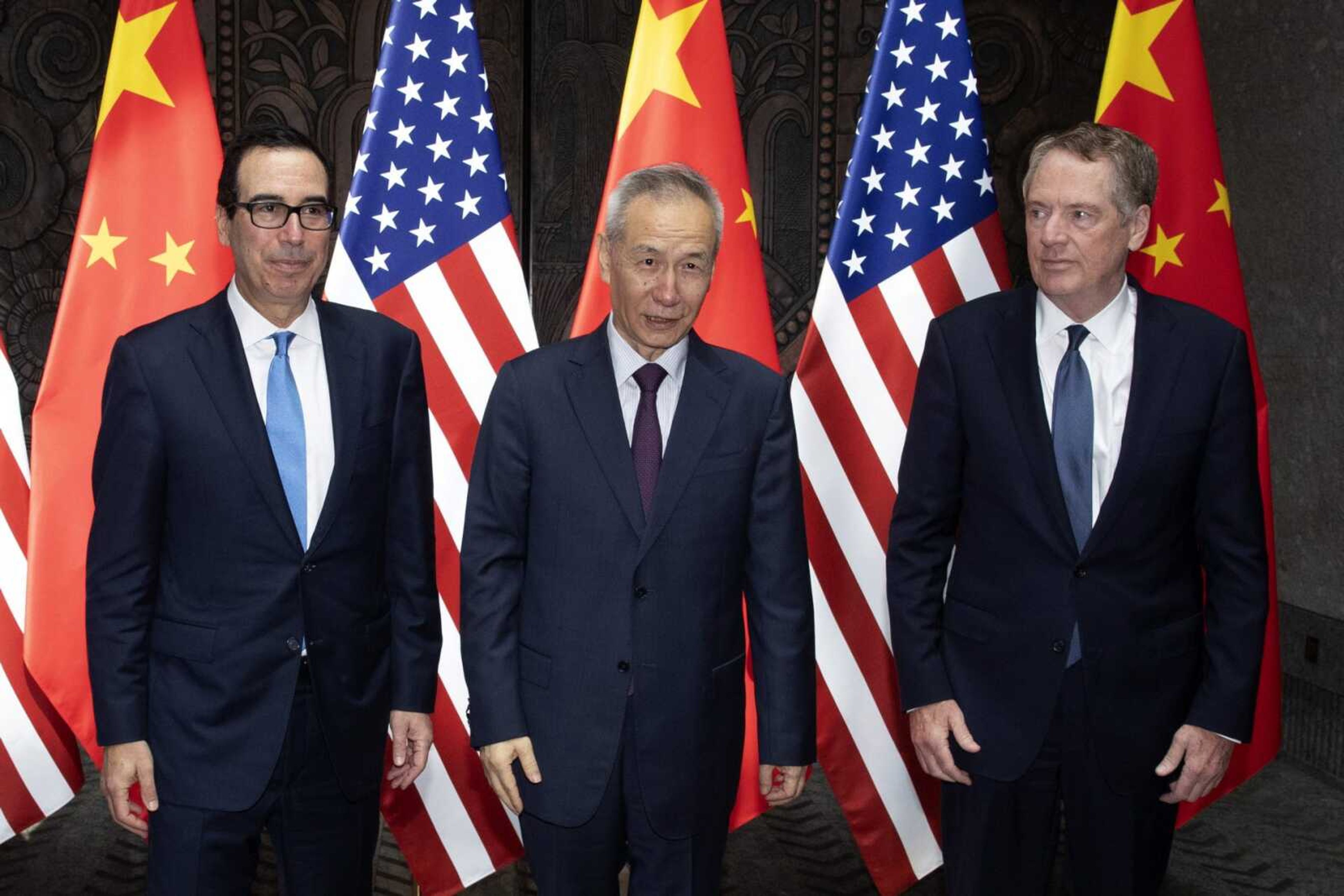 Chinese Vice Premier Liu He, center, poses with U.S. Trade Representative Robert Lighthizer, right, and Treasury Secretary Steven Mnuchin for photos Wednesday before holding talks at the Xijiao Conference Center in Shanghai.