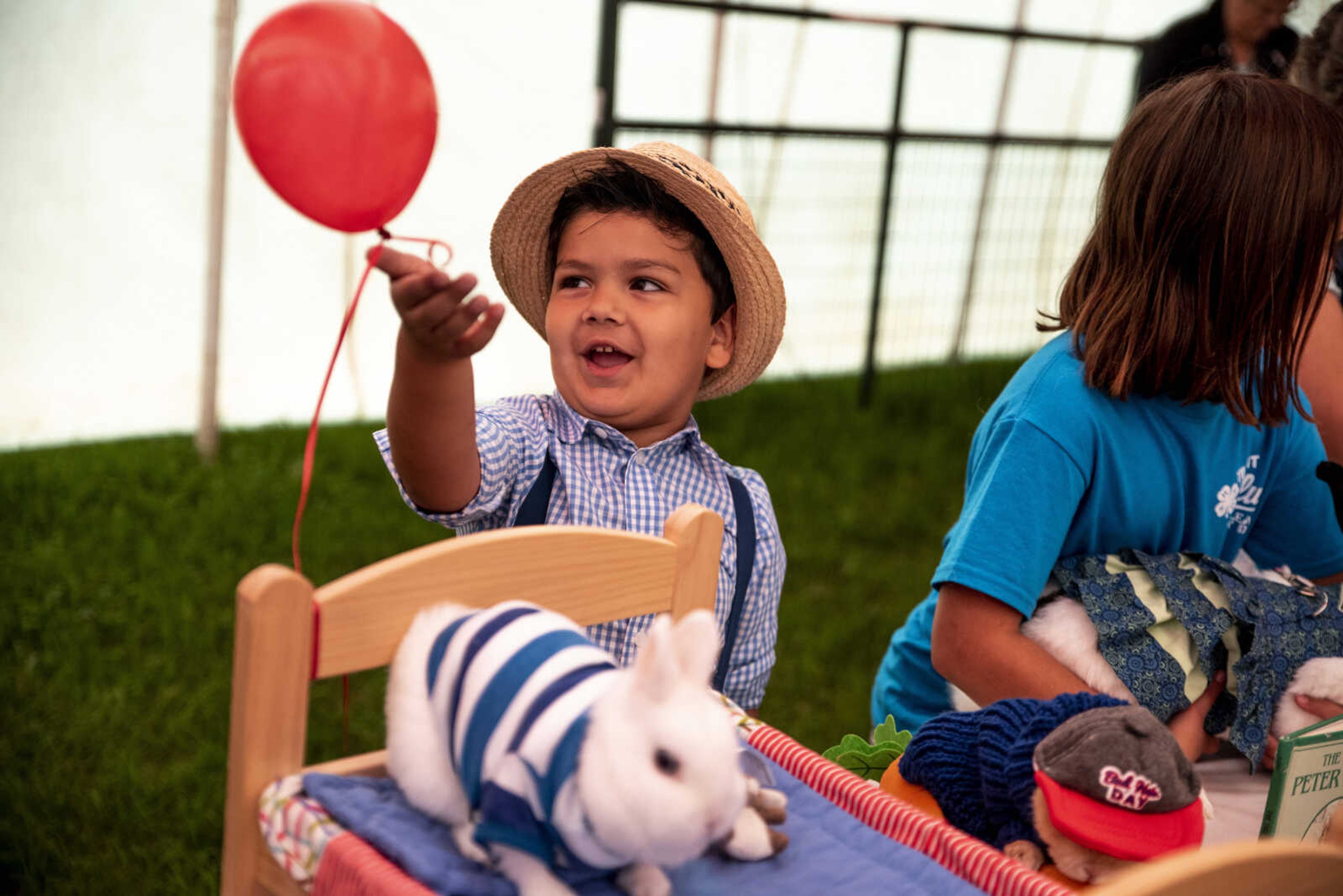 Eli Subramani, 5, adjusts the balloon tied to his bunny's toy bed during the Poultry and Rabbit Dress-Up Contest at the SEMO District Fair Sunday, Sept. 9, 2018 in Cape Girardeau.