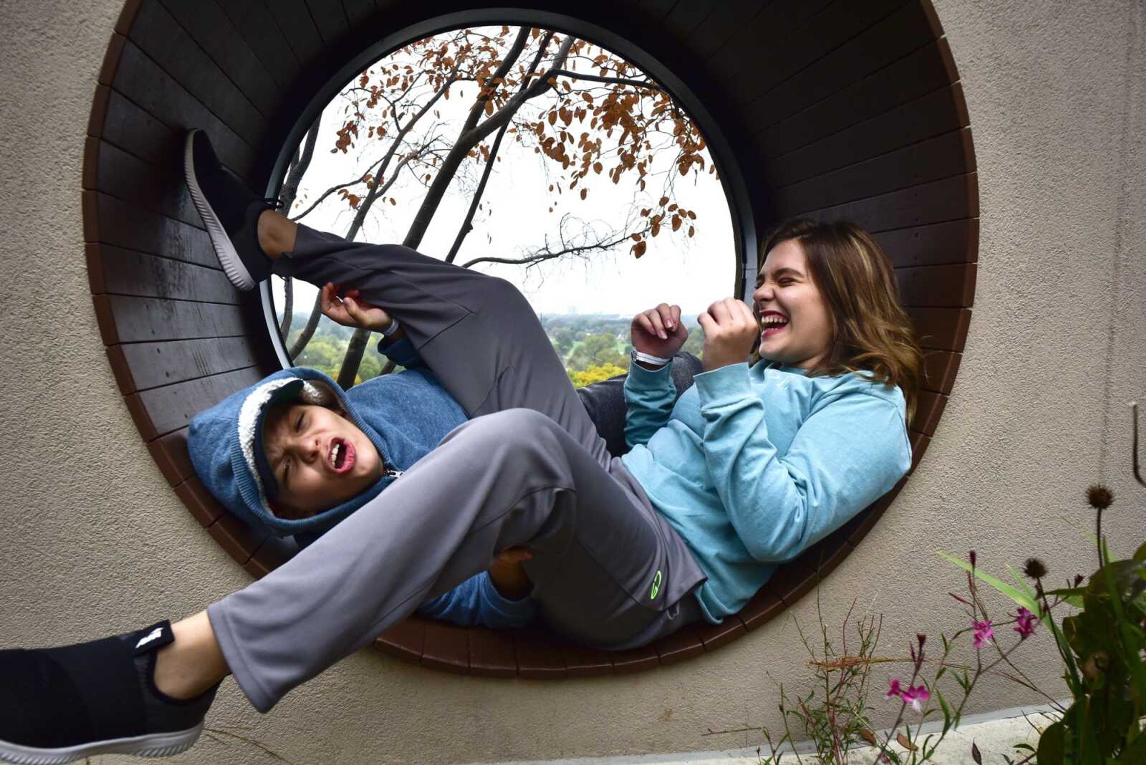 Allee McKee erupts in laughter after grossing out her 11-year-old twin brother Matthew during a break in a day of medical appointments Oct. 29 in The Olson Family Garden at St. Louis Children's Hospital.