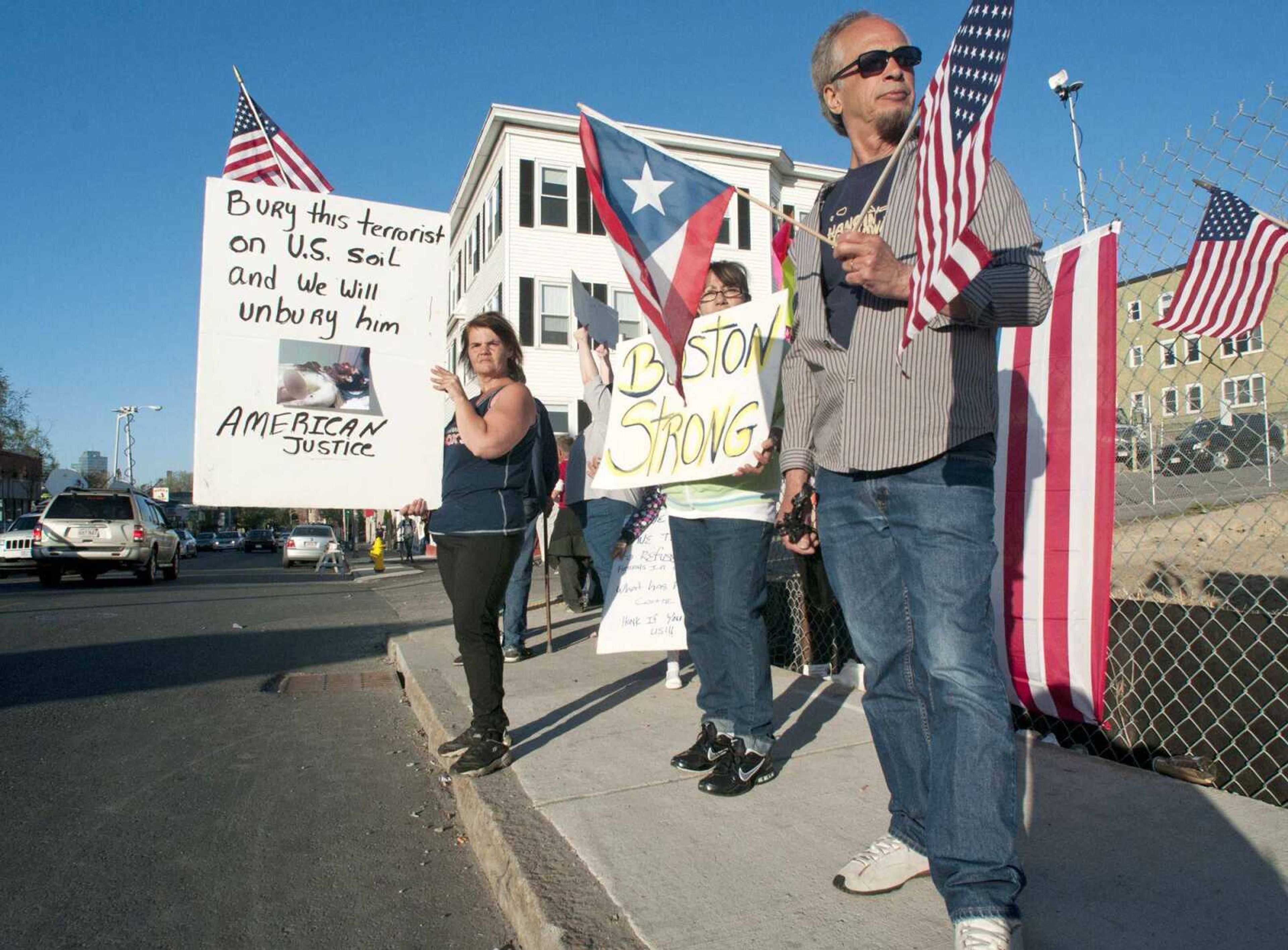 From left, Lisa Taurasi, Lucy Rodriguez and Luis Barbosa, all of Worcester, Mass., protest across the street from Graham Putnam &amp; Mahoney Funeral Parlors in Worcester, Mass. on Sunday. (Betty Jenewin ~ Associated Press)