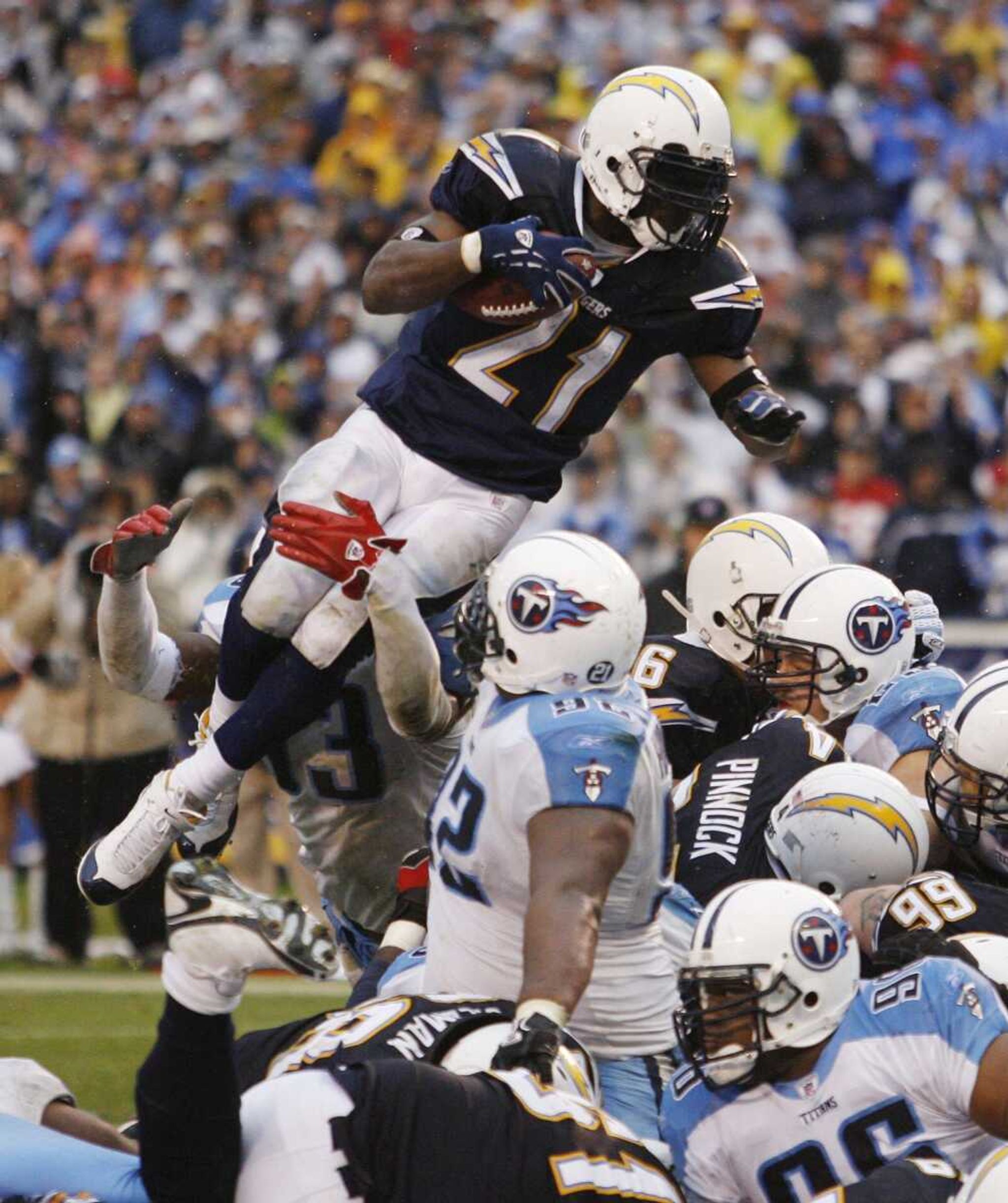 San Diego Chargers' LaDainian Tomlinson (21) leaps over the Tennessee Titans defense to score a one-yard touchdown during the fourth quarter of their AFC wild-card game Sunday, Jan. 6, 2008, in San Diego.   (AP Photo/Denis Poroy)