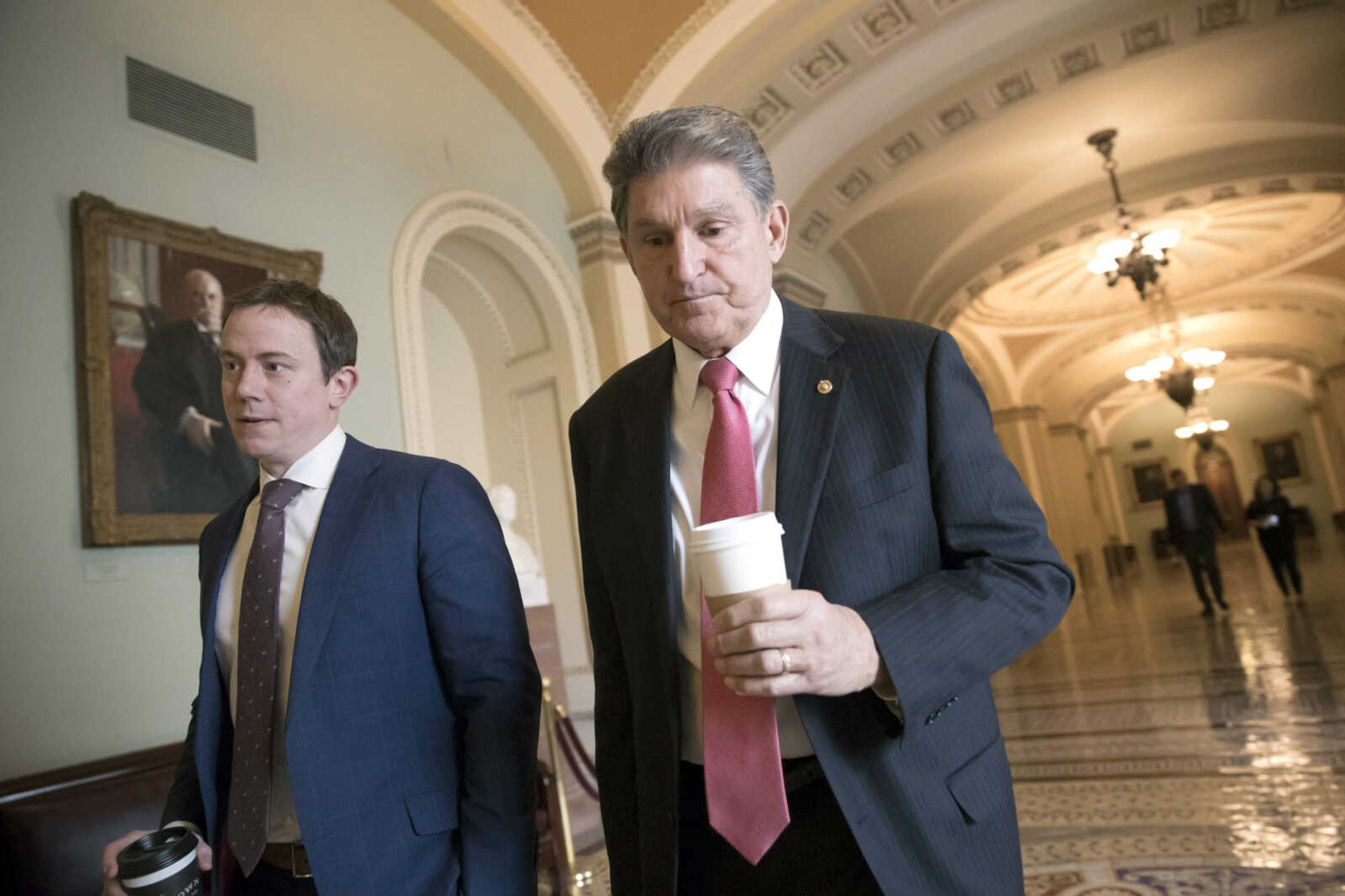 Sen. Joe Manchin, D-W.Va., walks to the office of Senate Minority Leader Chuck Schumer, D-N.Y., on Day 2 of the federal shutdown, at the Capitol on Sunday in Washington.