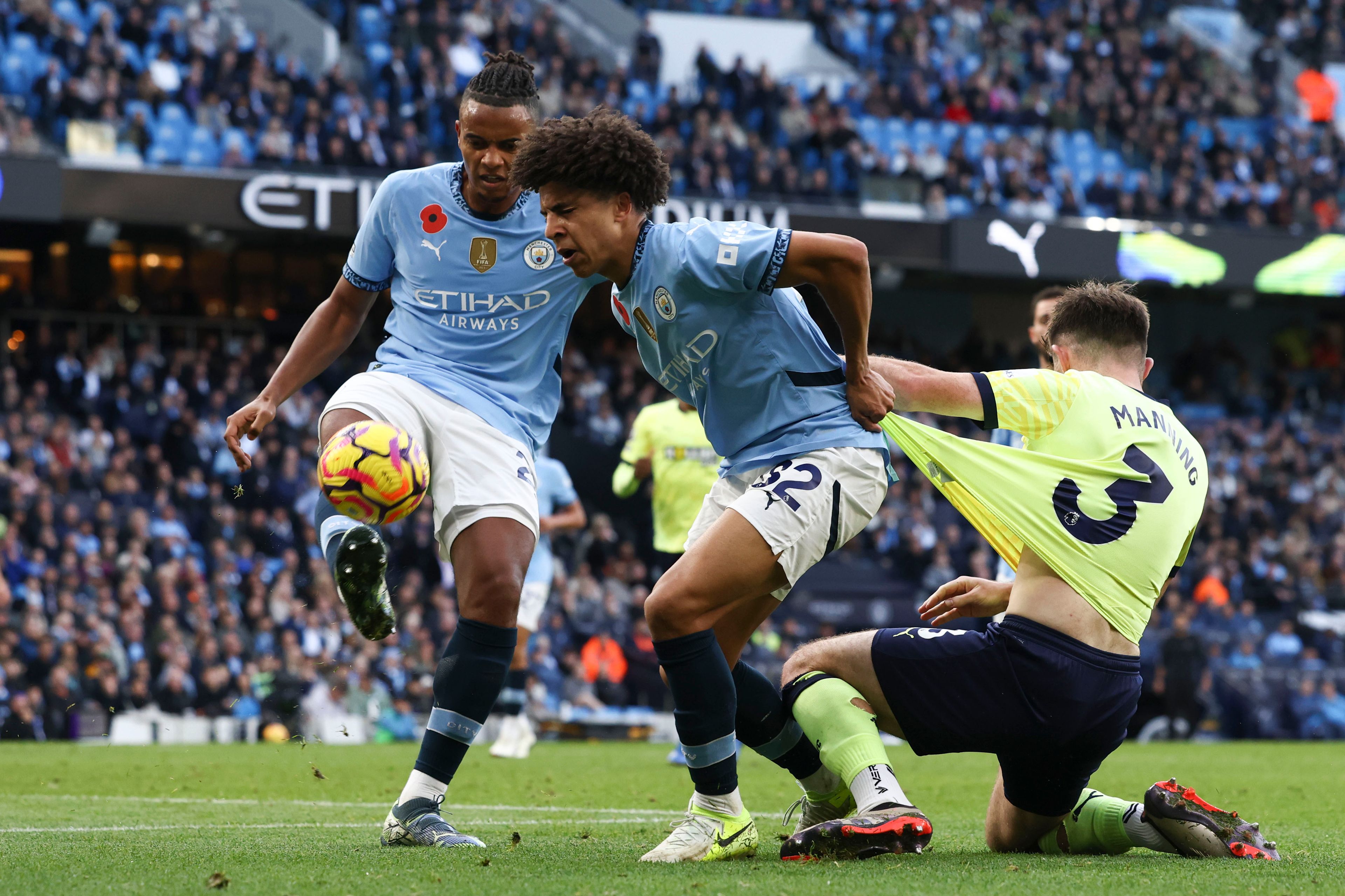 Southampton's Ryan Manning, right, duels for the ball with Manchester City's Rico Lewis, center, and Manchester City's Manuel Akanji during the English Premier League soccer match between Manchester City and Southampton at the Etihad Stadium in Manchester, England, Saturday, Oct. 26, 2024. (AP Photo/Darren Staples)