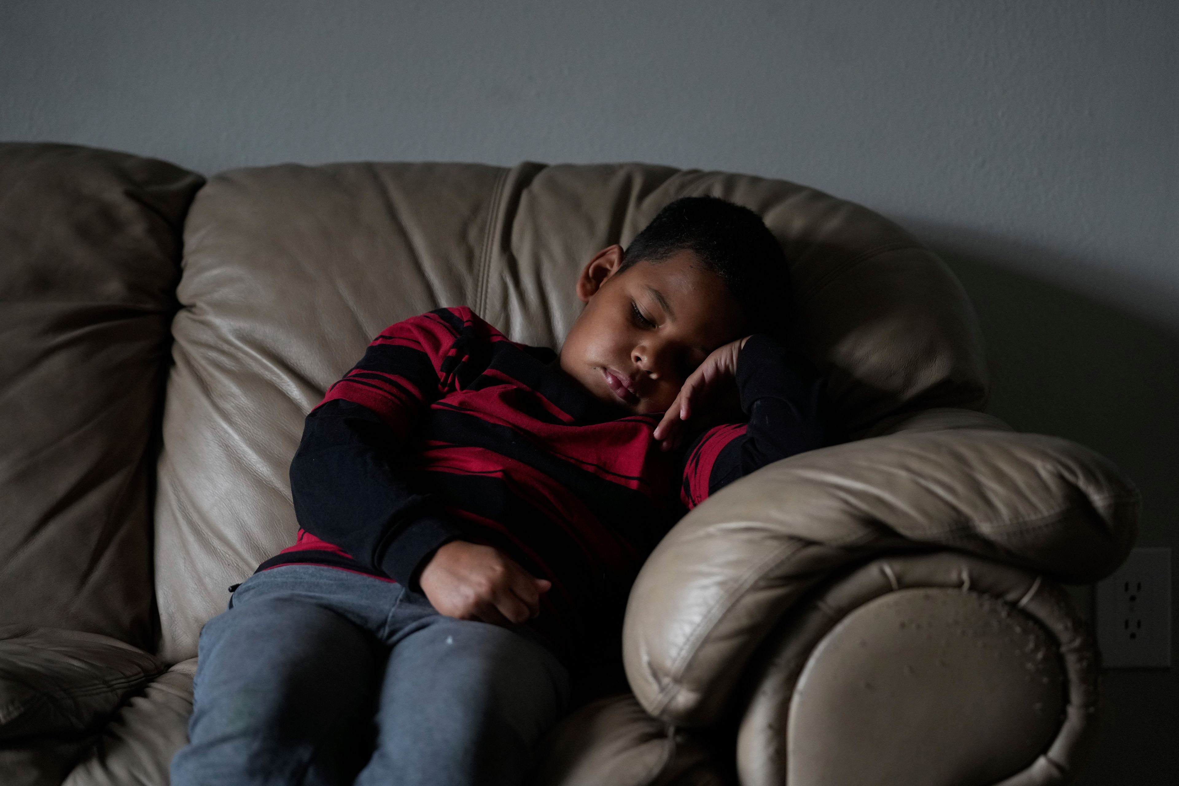 Dylan Martínez-Ramírez rests before walking to school with his mother Thursday, Aug. 29, 2024, in Aurora, Colo. (AP Photo/Godofredo A. Vásquez)