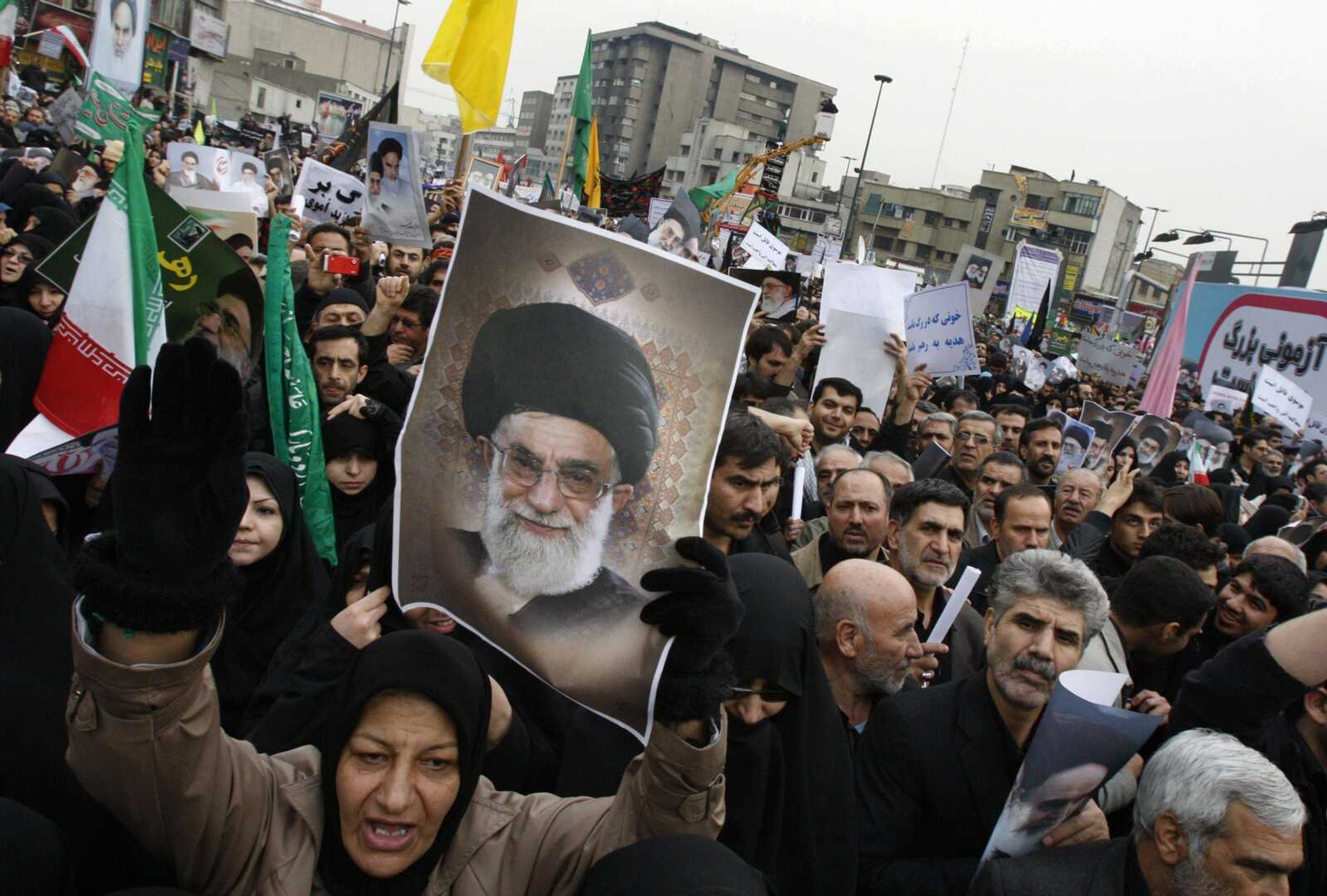 Chanting slogans, a female Iranian demonstrator holds a poster of supreme leader Ayatollah Ali Khamenei during a pro-government rally Wednesday at the Enqelab (Revolution) Sqare in Tehran, Iran. (Vahid Salemi ~ Associated Press)