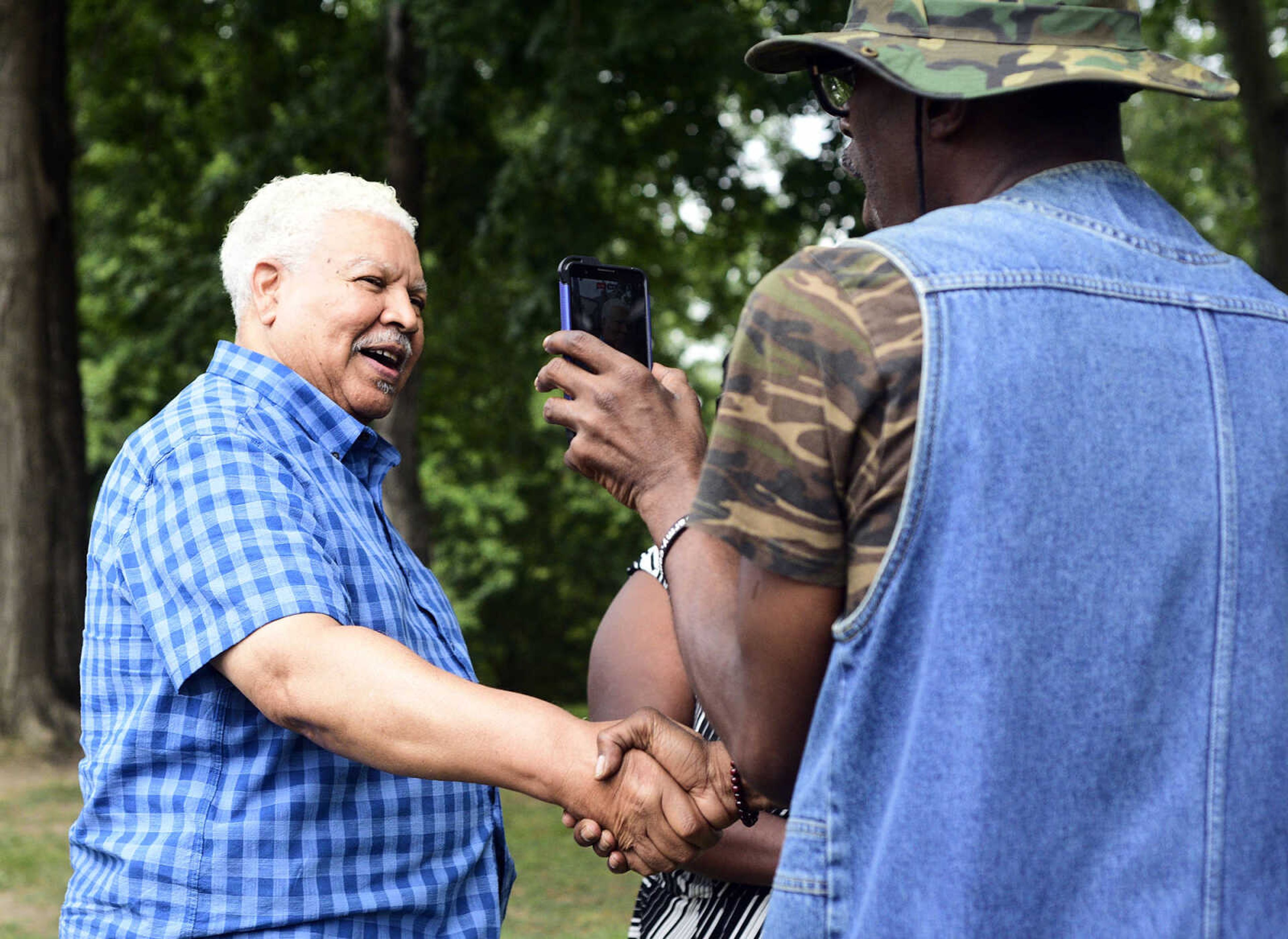 Michael "The Navigator" Council right, greets Bill Colon during the Love, Not Hate rally on Sunday evening, Aug. 13, 2017, at Ivers Square in Cape Girardeau.