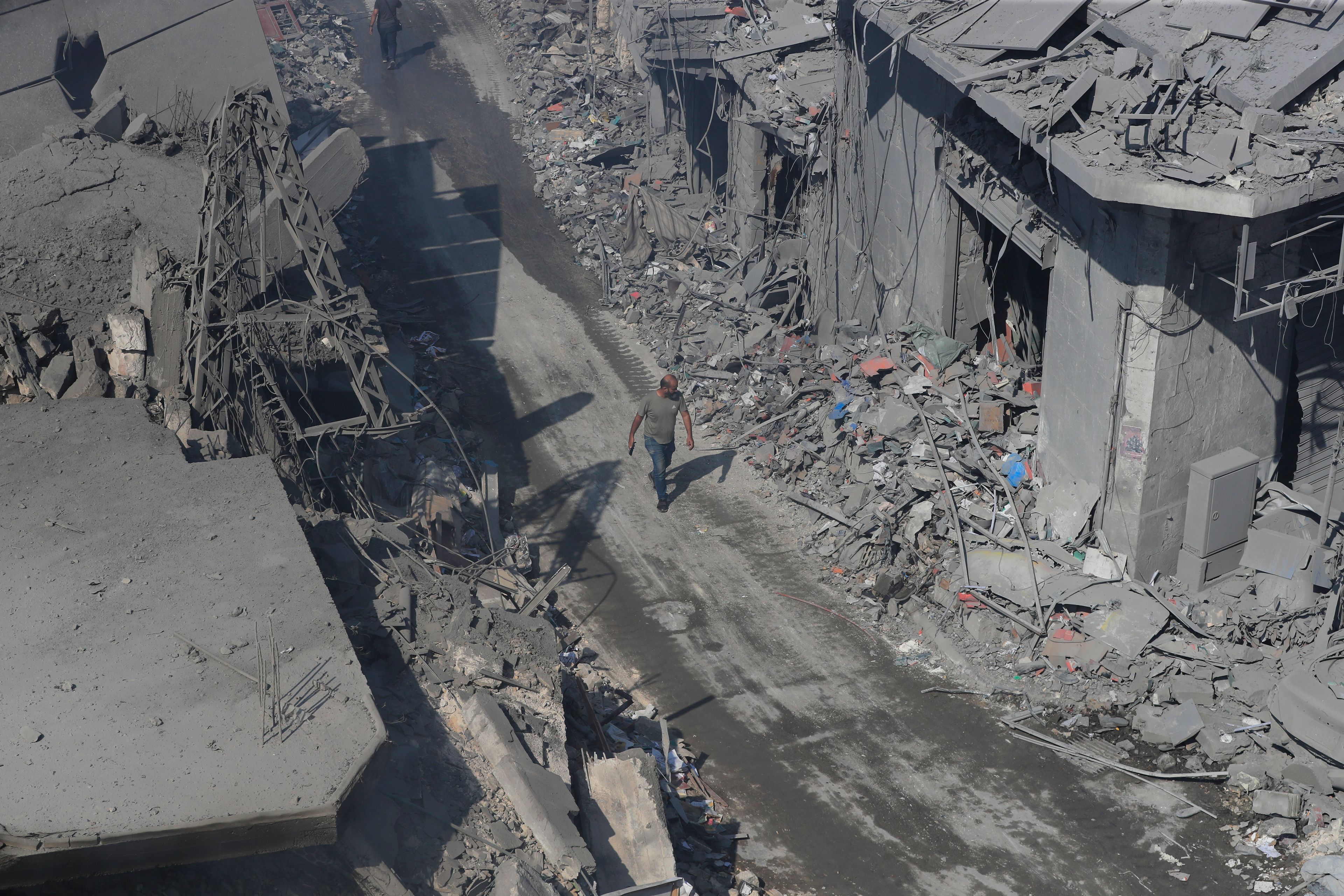 A man walks amid destroyed buildings at a commercial street that was hit Saturday night by Israeli airstrikes, in Nabatiyeh town, south Lebanon, Sunday, Oct. 13, 2024. (AP Photo/Mohammed Zaatari)