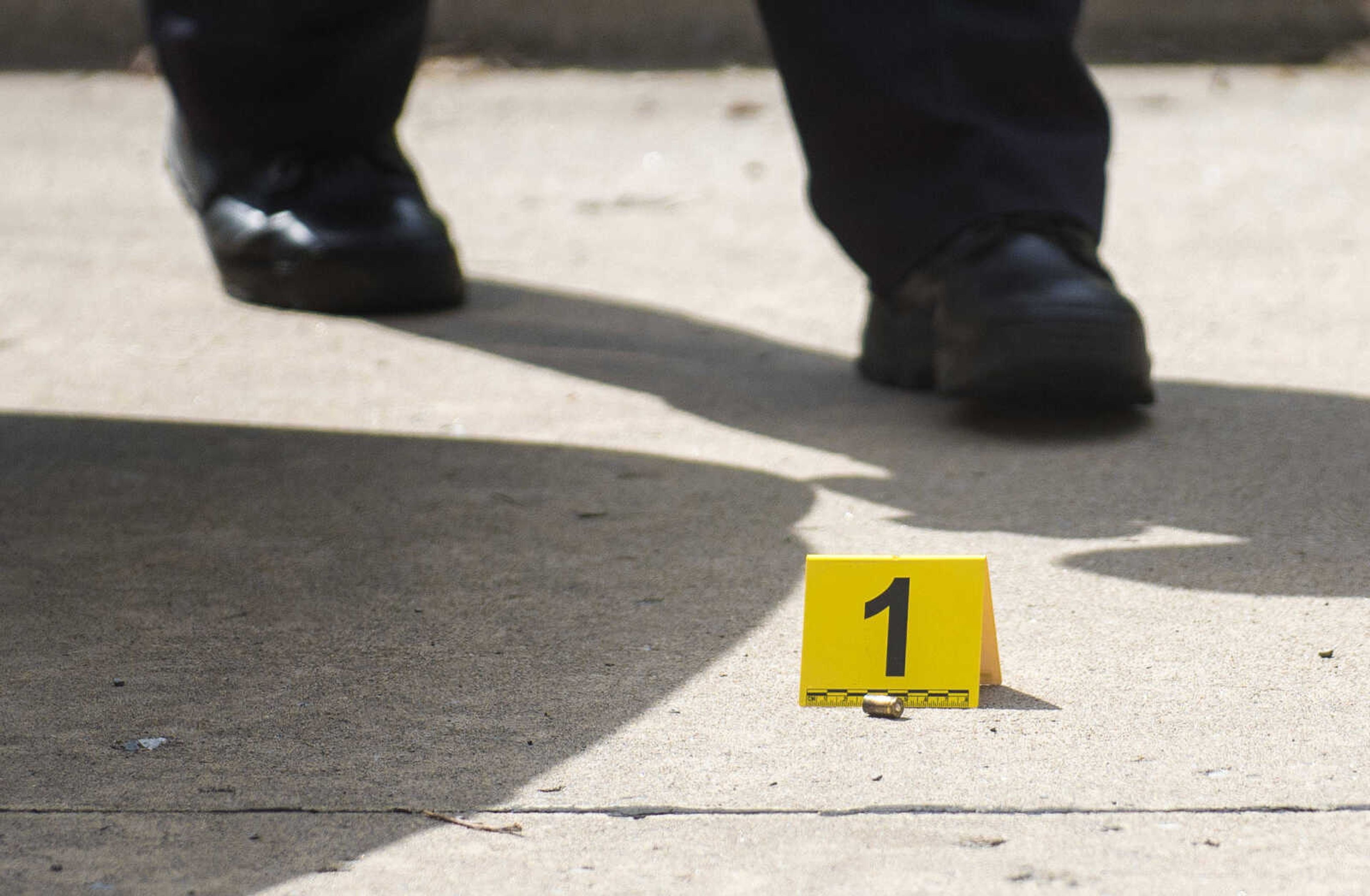 A shell casing is seen near the rear bumper of a police car in a taped-off area of the street as Cape Girardeau Police investigate a shooting Monday in the 100 block of South Park Avenue.