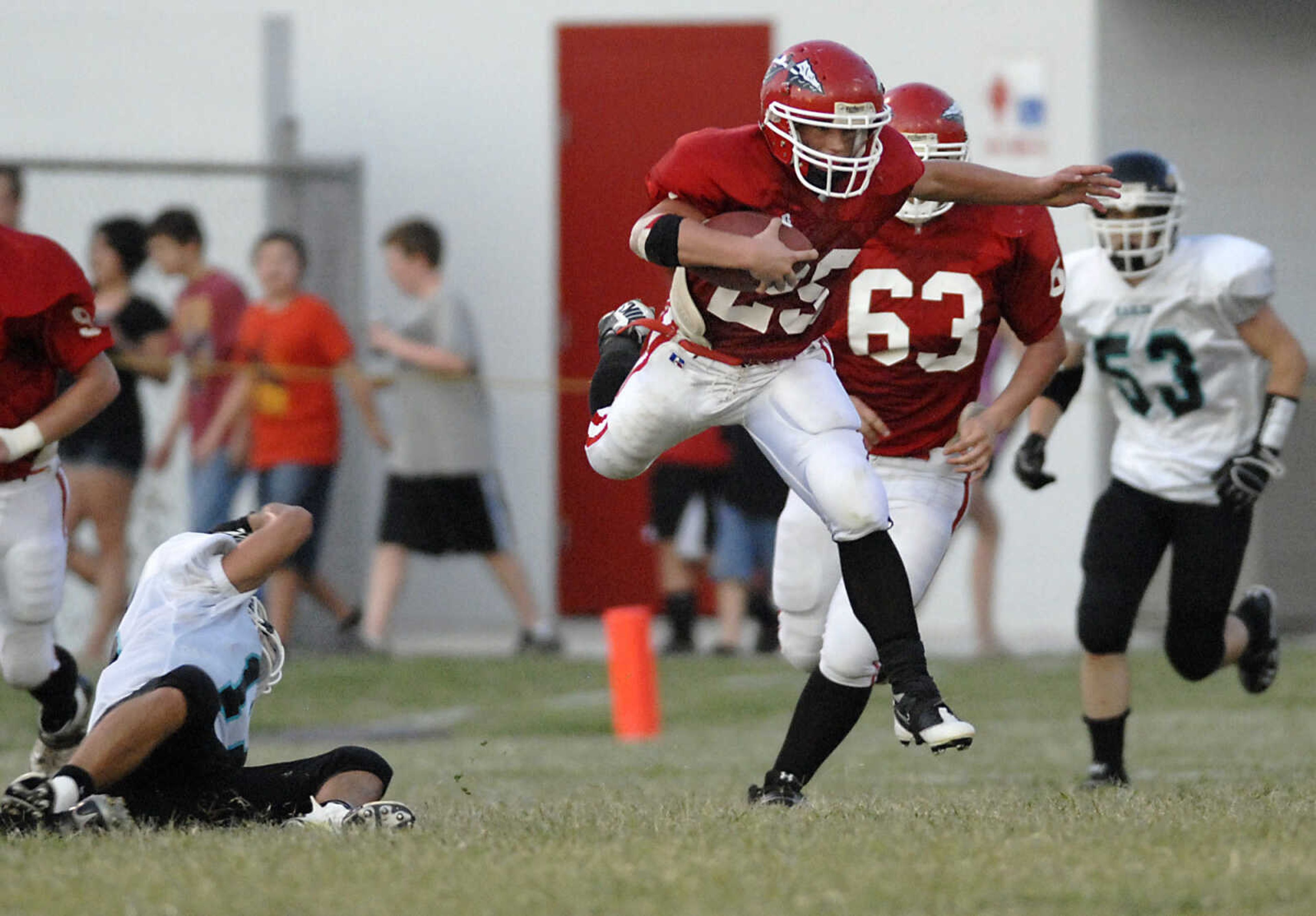 Jackson's Colten Proffer jumps over O'Fallon Christian's Corey Light, left, as he runs the ball during the first quarter of a game on Friday, Aug. 26, 2011, in Jackson. Jackson lost 33-30. (Kristin Eberts)