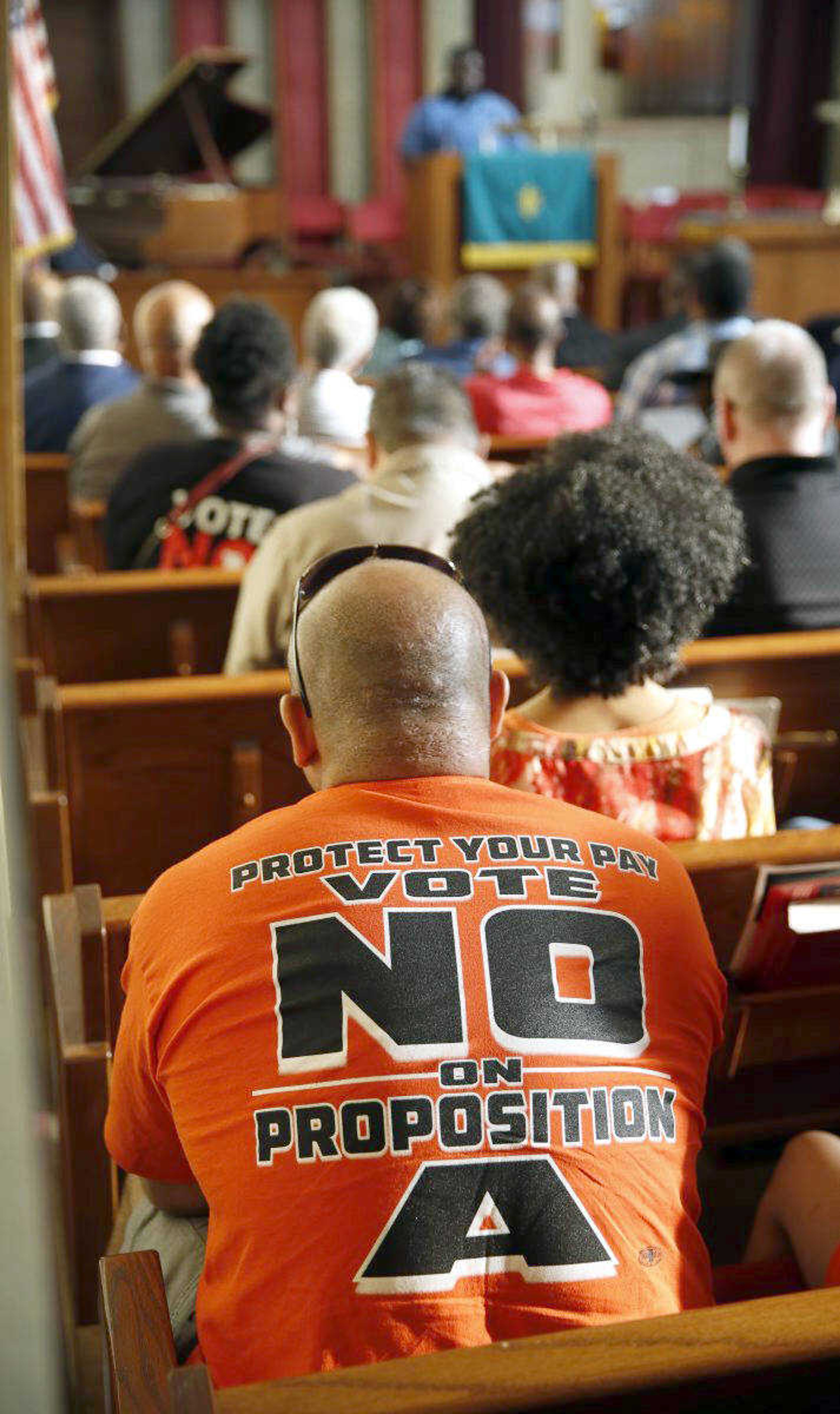 People opposing Proposition A listen to a speaker July 31 during a rally in Kansas City, Missouri.