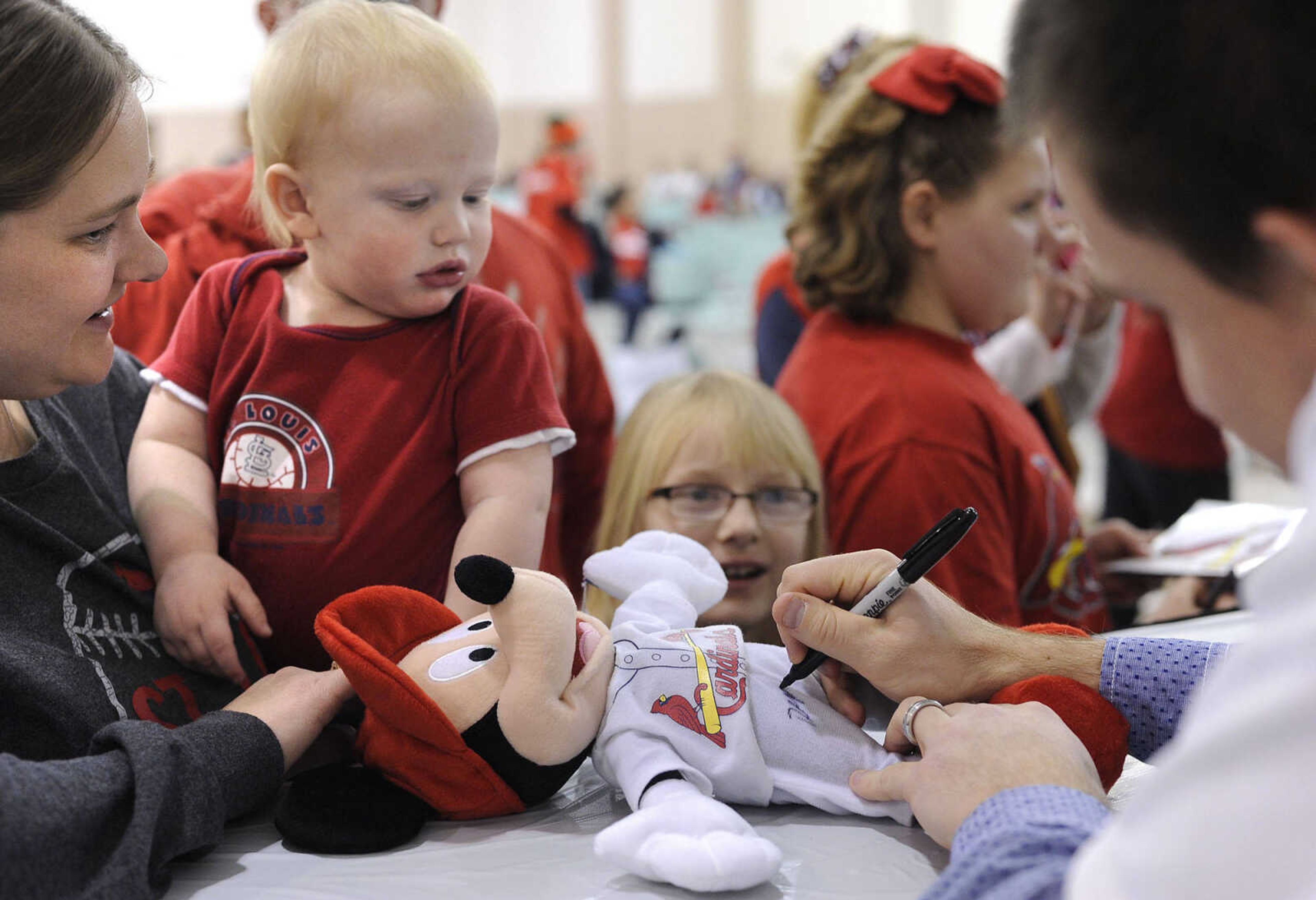 FRED LYNCH ~ flynch@semissourian.com
Dean Kiekhefer autographs a Mickey Mouse toy for Alex Wybert and his mother, Stephanie Wybert of Cape Girardeau, during the Cardinals Caravan on Monday, Jan. 18, 2016 at the Osage Centre.