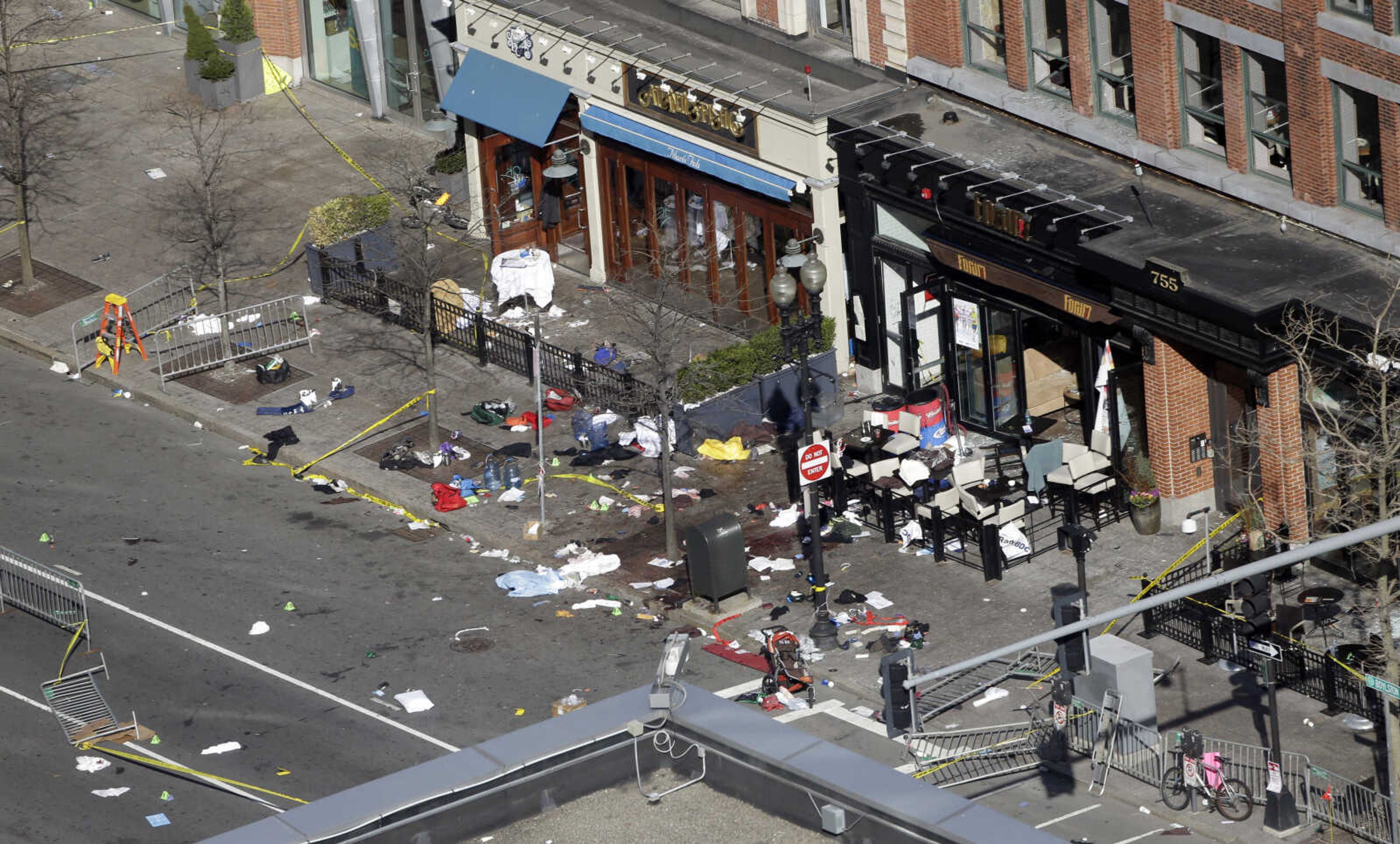 One of the blast sites on Boylston Street near the finish line of the 2013 Boston Marathon is seen in Boston, Tuesday, April 16, 2013, one day after bomb blasts killed three and injured over 140 people. FBI agents searched a suburban Boston apartment overnight and appealed to the public for amateur video and photos that might yield clues to who carried out the Boston Marathon bombing. (AP Photo/Elise Amendola)