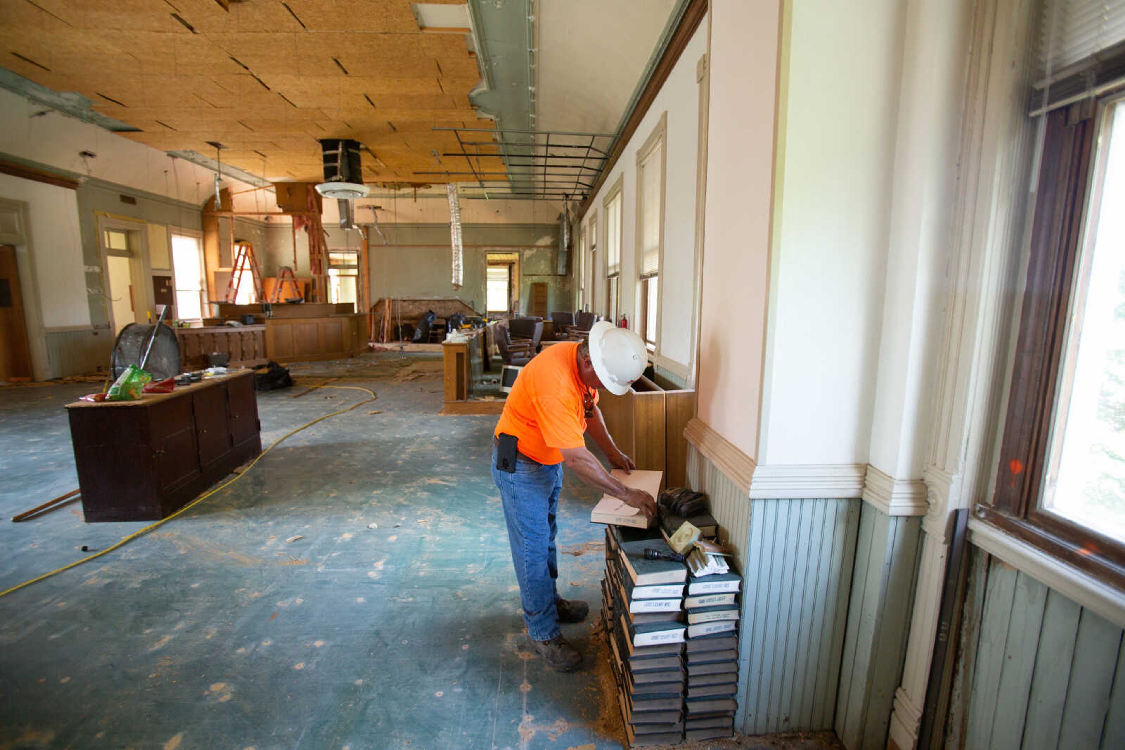 Project superintendent David Marigeaux flips through an old book of legal forms from a volume that sits in the corner of the courtroom as his crew continues the demolition phase of the Common Pleas Courthouse renovation on Tuesday, June 16, 2020.