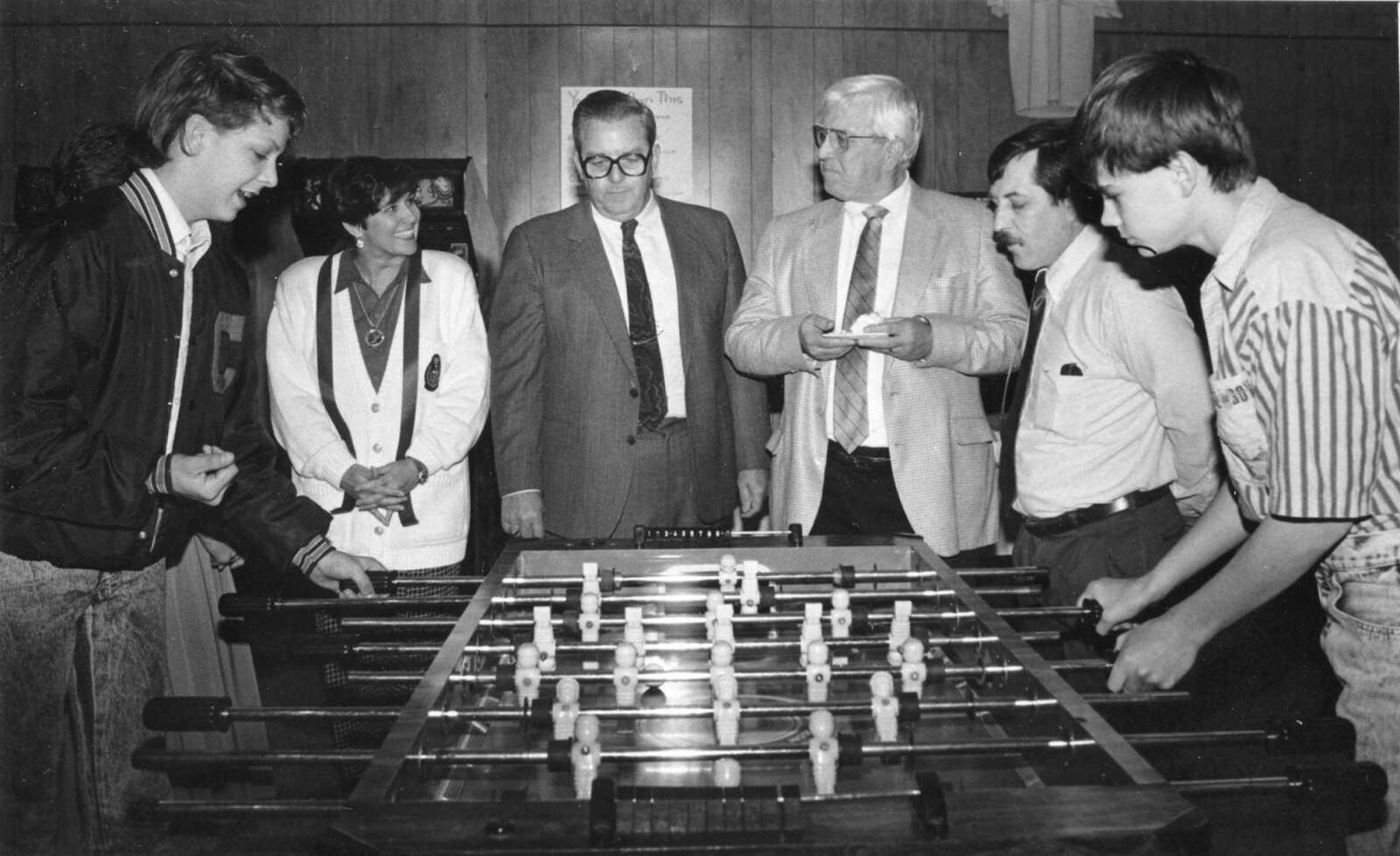 Published March 4, 1990.
A ribbon-cutting ceremony Saturday marked the official opening of Cape Girardeau's non-profit Teen Activity Center, located at the corner of East Plaza Way and Sheridan. After the ceremony, Don Riley Jr., far left, and Ryann Juden, second from right, of Cape, tried their hand at a game of soccer. Watching the boys are, left to right, Debbie Oliver, secretary and member of the center's board of directors; Mayor Gene Rhodes, Cape Girardeau Chamber of Commerce President Bob Hendrix, and Teen Center Director Les Lindy. (Southeast Missourian archive photo)