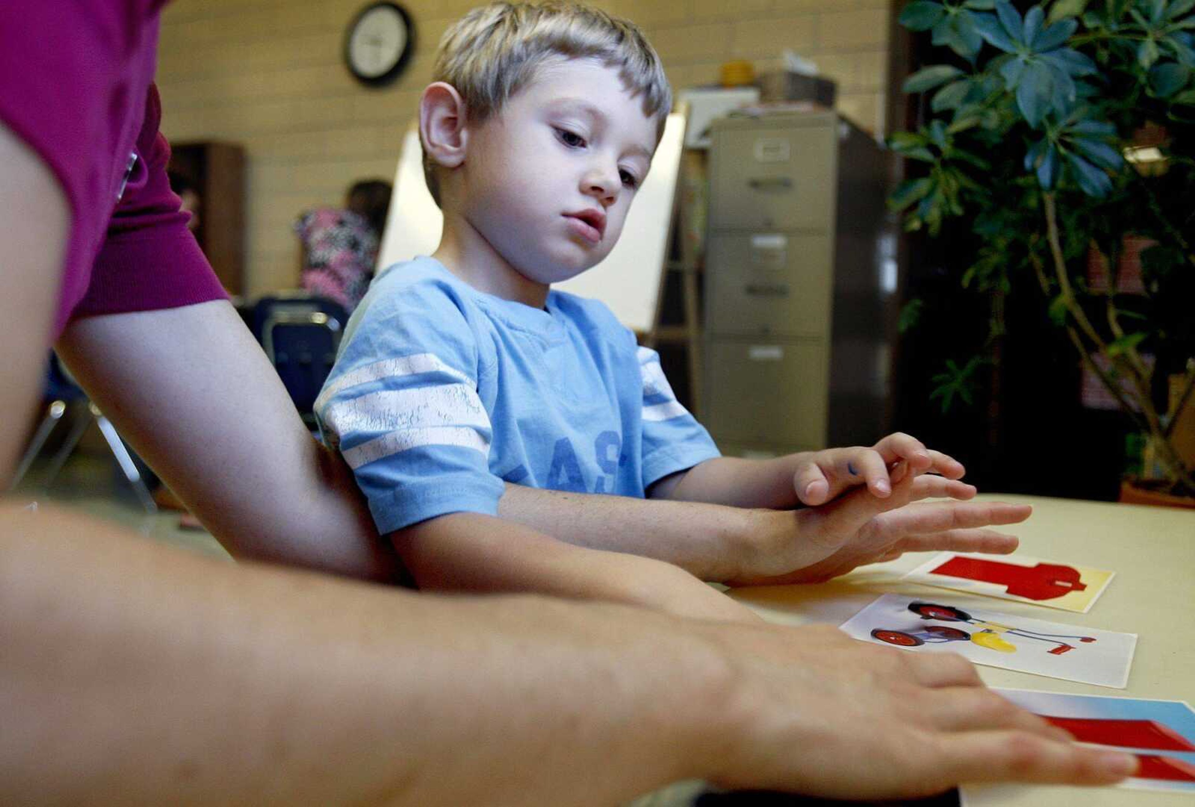 Resource interventionist Megan Hahs of Friedheim works with Gavin McFall, 3, who has autism, by having him point to objects on a card Friday at Oak Ridge Elementary School. (Elizabeth Dodd)