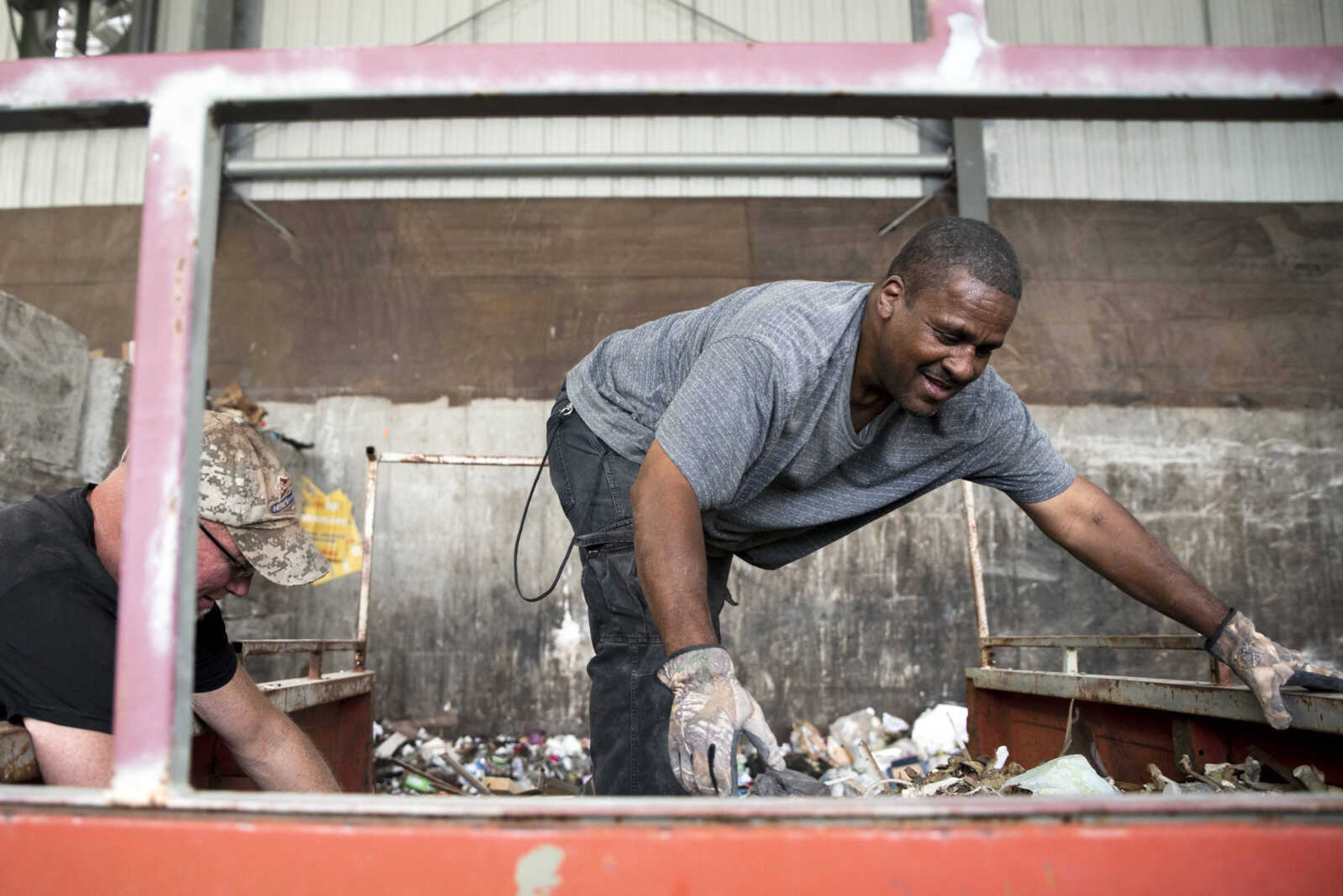 Sebastian Todd Thomas, right, helps Danny Rees unload his truck of gutted house material Monday at the Cape Girardeau Public Works Transfer Station in Cape Girardeau.