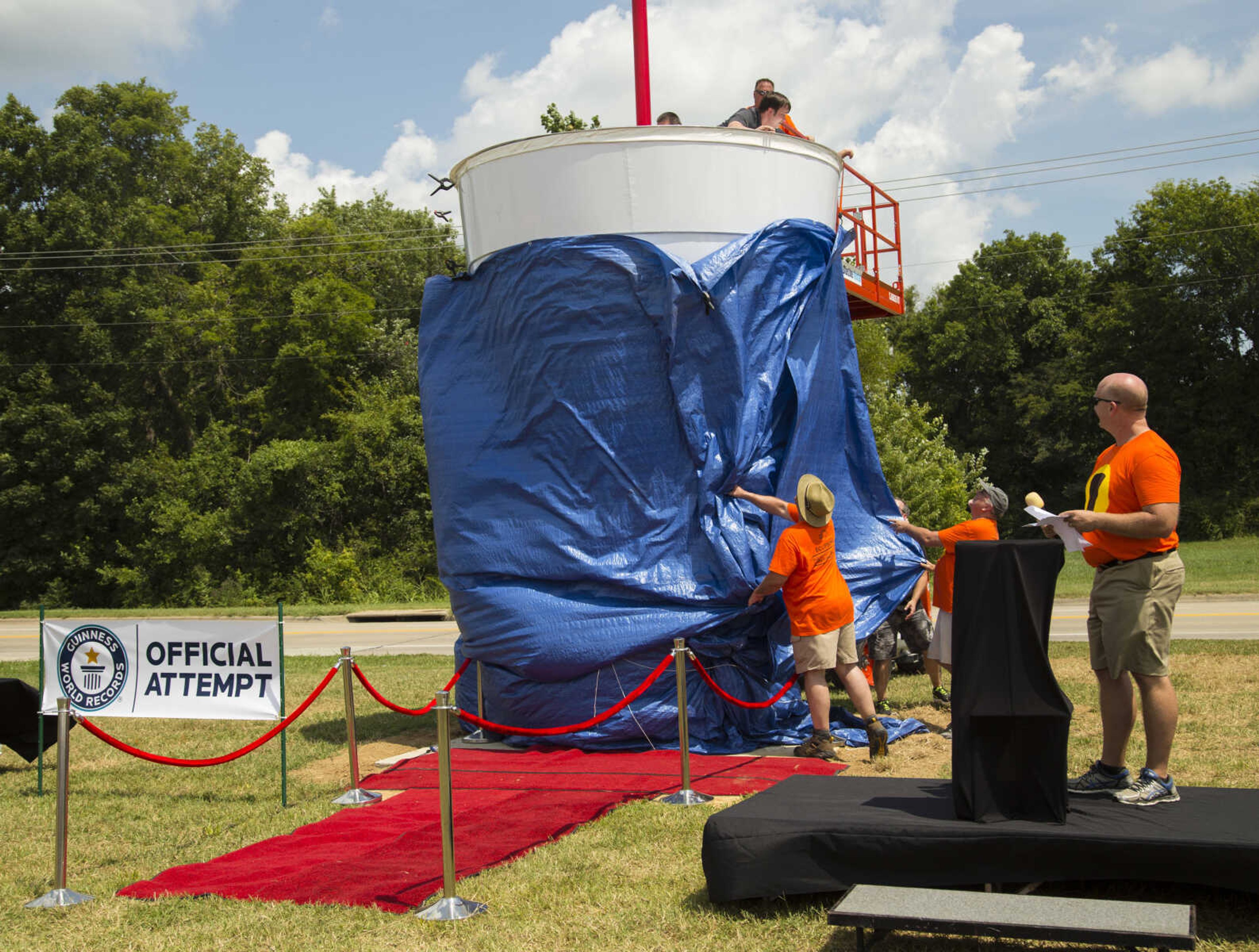 Rhodes 101 vice-president Brent Anderson looks back for the unveiling of their gigantic cup of lemonade Sunday afternoon at Mercato Di Rodi in Cape Girardeau.