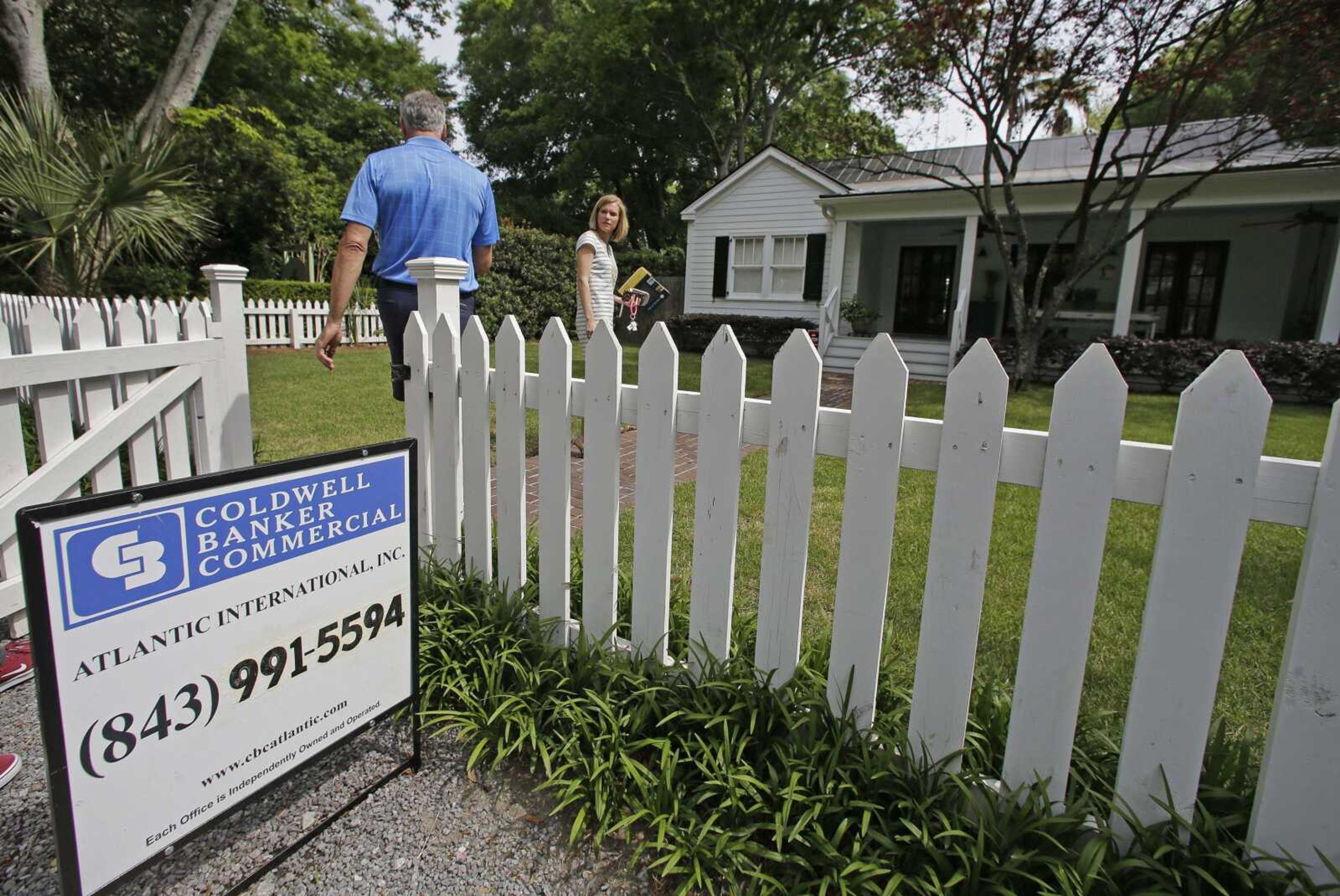 Real-estate agent Lauren Newman, right, prepares to show Steve Martin a home for sale April 20 in Mount Pleasant, South Carolina. If you're about to buy a home, shop for a car or borrow for college, the pros say: Go ahead. The Fed's move to raise its key rate should have little effect on mortgages or auto and student loans.