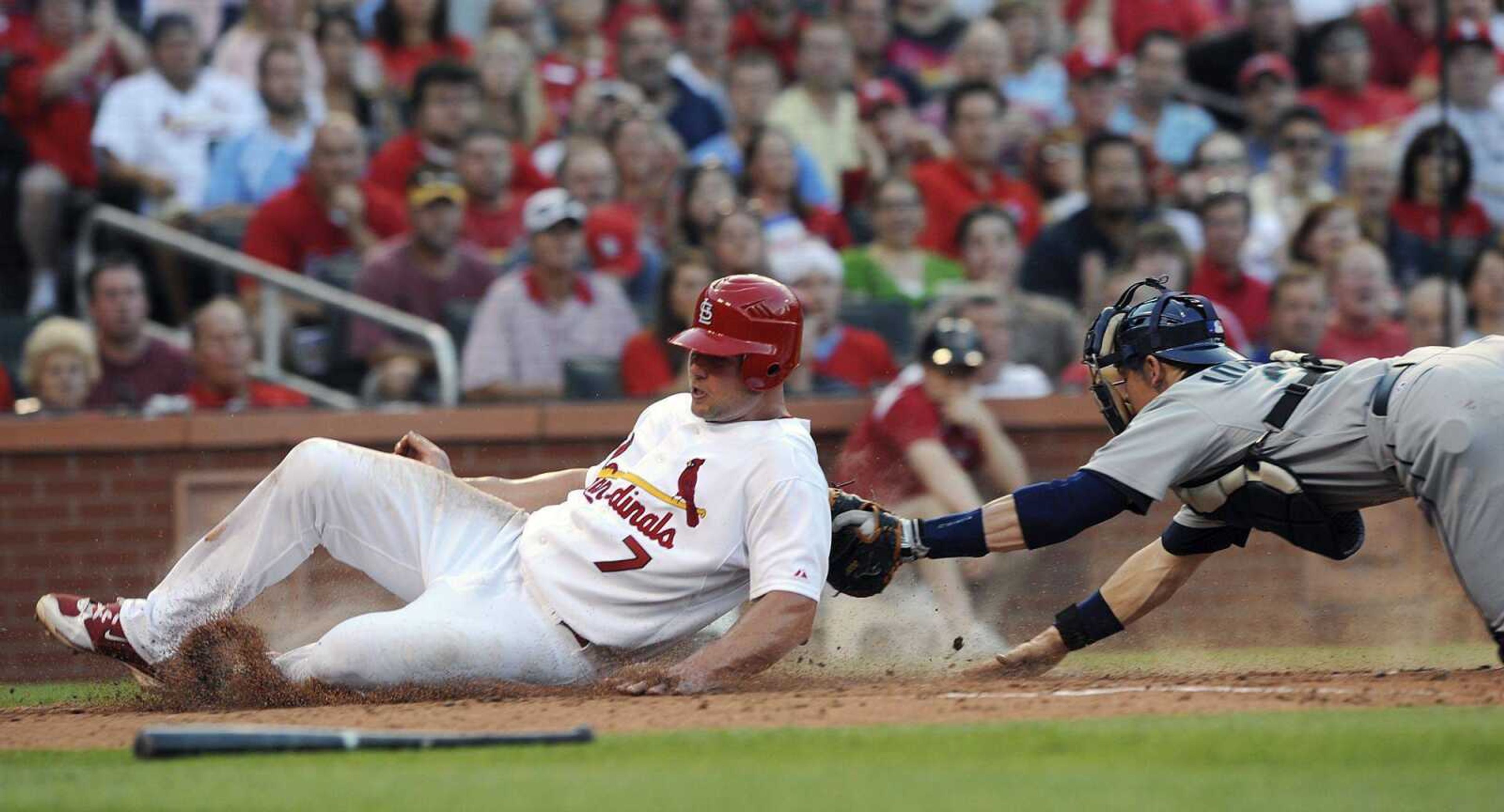 Cardinals base runner Matt Holliday scores past the tag of Mariners catcher Rob Johnson during the third inning Monday in St. Louis. (BILL BOYCE ~ Associated Press)