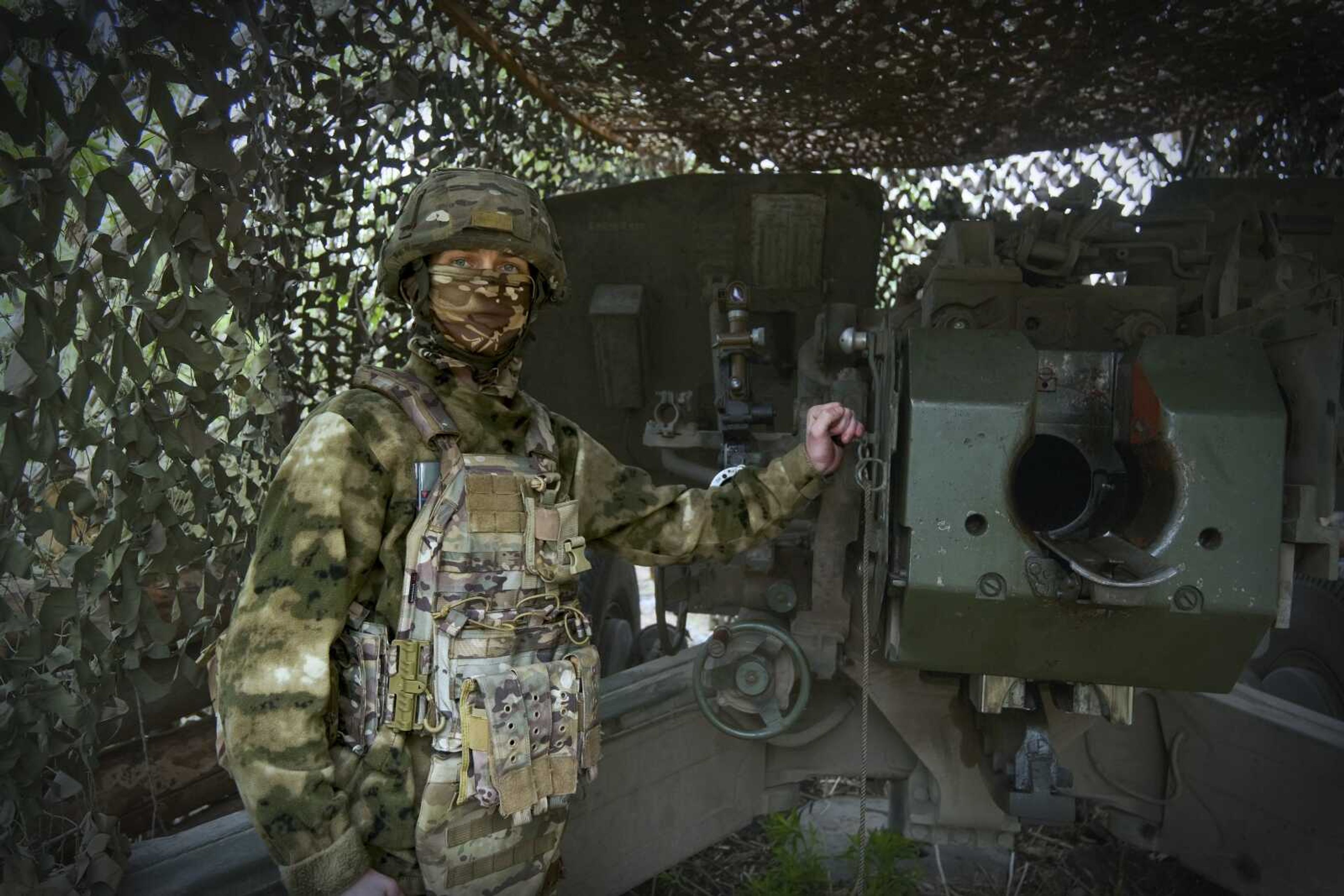 In this photo taken April 26, a Russian soldier poses for a photo next to a 2A65 "Msta-B" howitzer at a position in an undisclosed location in Ukraine.