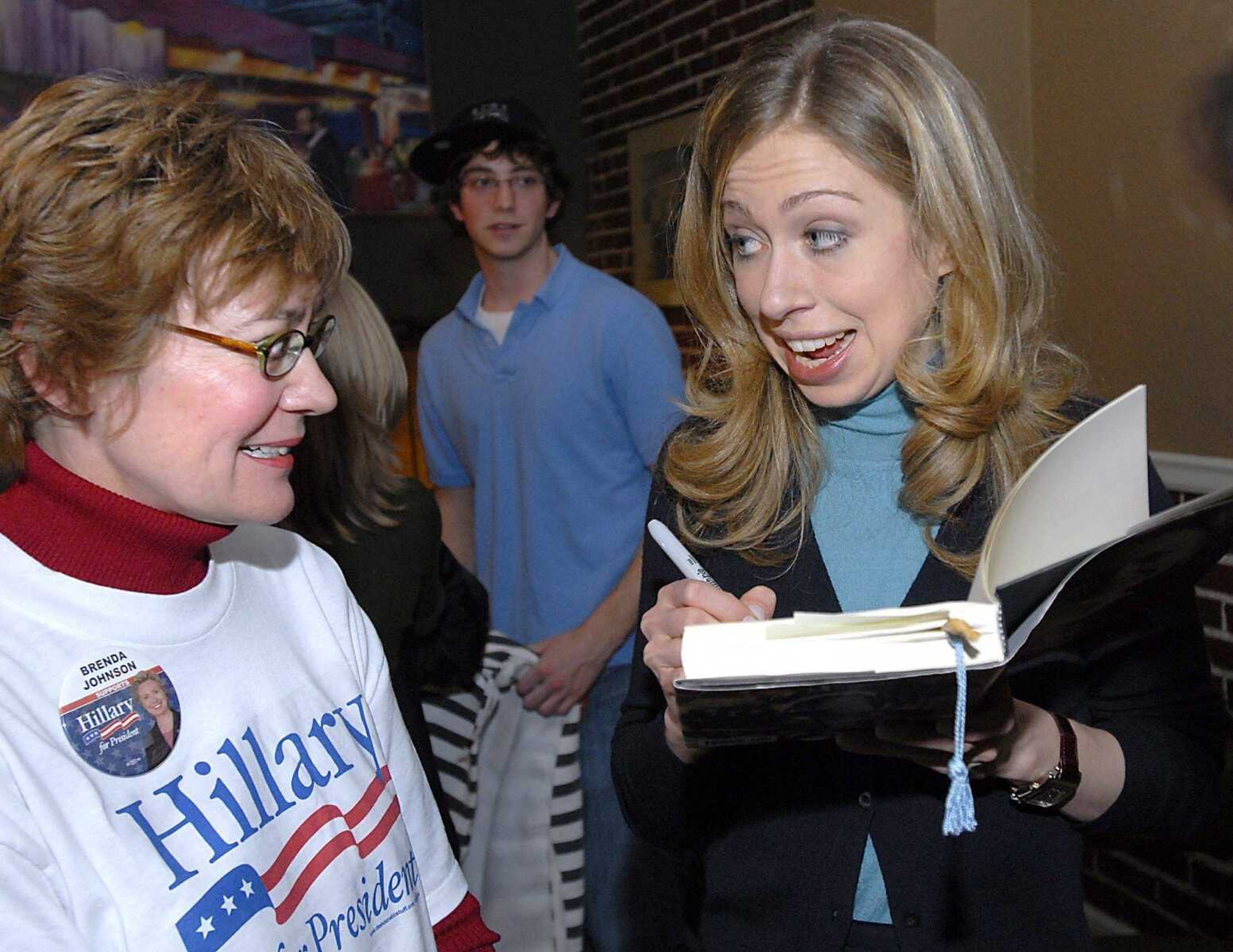 Chelsea Clinton, right, signed a book by her mother, Hillary Clinton, for Brenda Johnson after speaking Sunday night at Grace Cafe. (Fred Lynch)