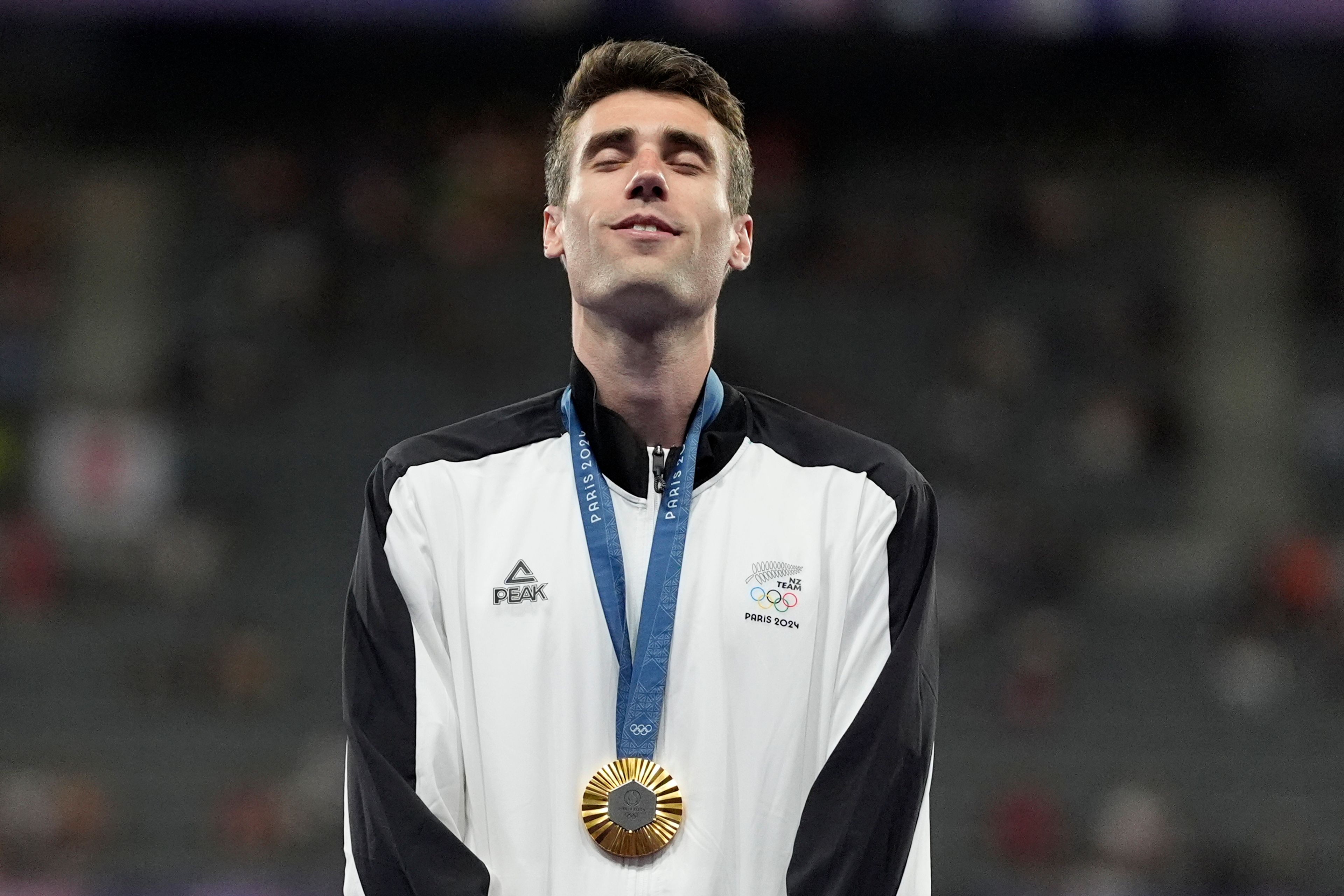 Men's high jump gold medalist, Hamish Kerr, of New Zealand, stands on the podium, at the 2024 Summer Olympics, Saturday, Aug. 10, 2024, in Saint-Denis, France. (AP Photo/Matthias Schrader)