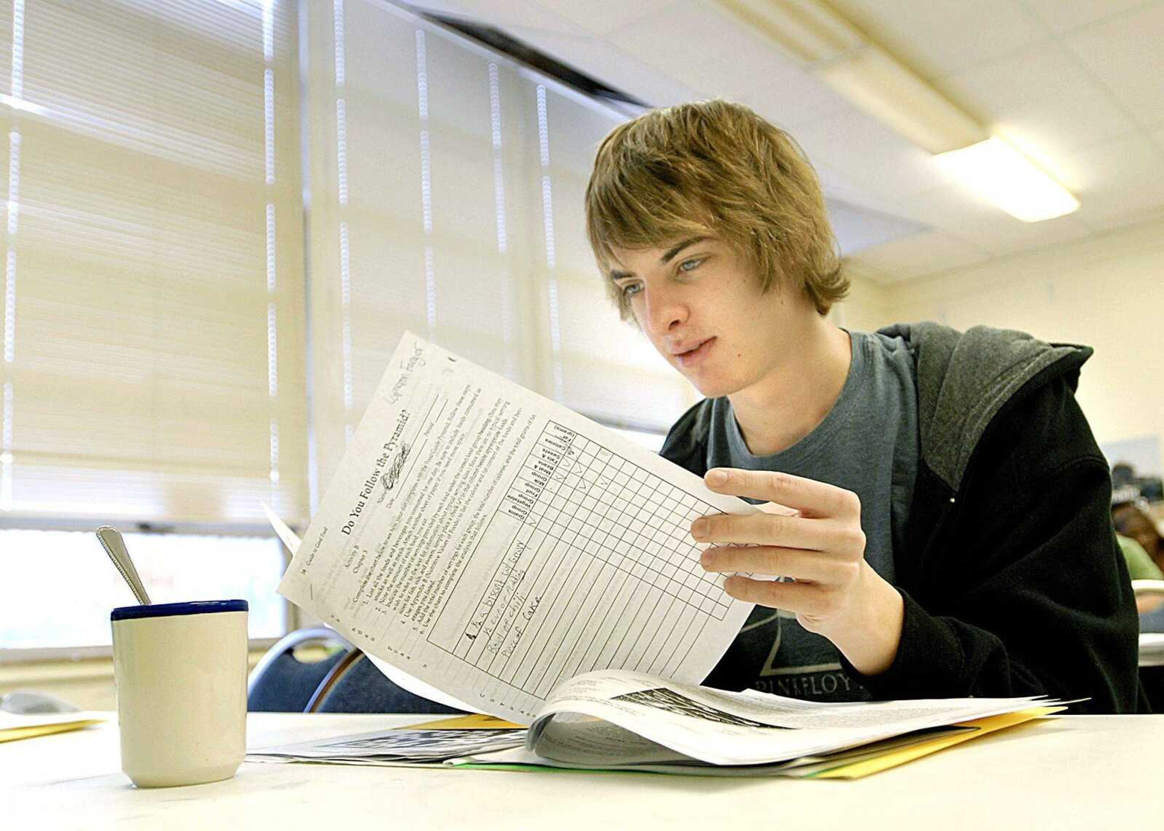 With a cup of chicken noodle soup in front of him, Cameron Fanger, a junior at the Alternative Education Center, looked over a worksheet during his food sciences class Wednesday. (Aaron Eisenhauer)