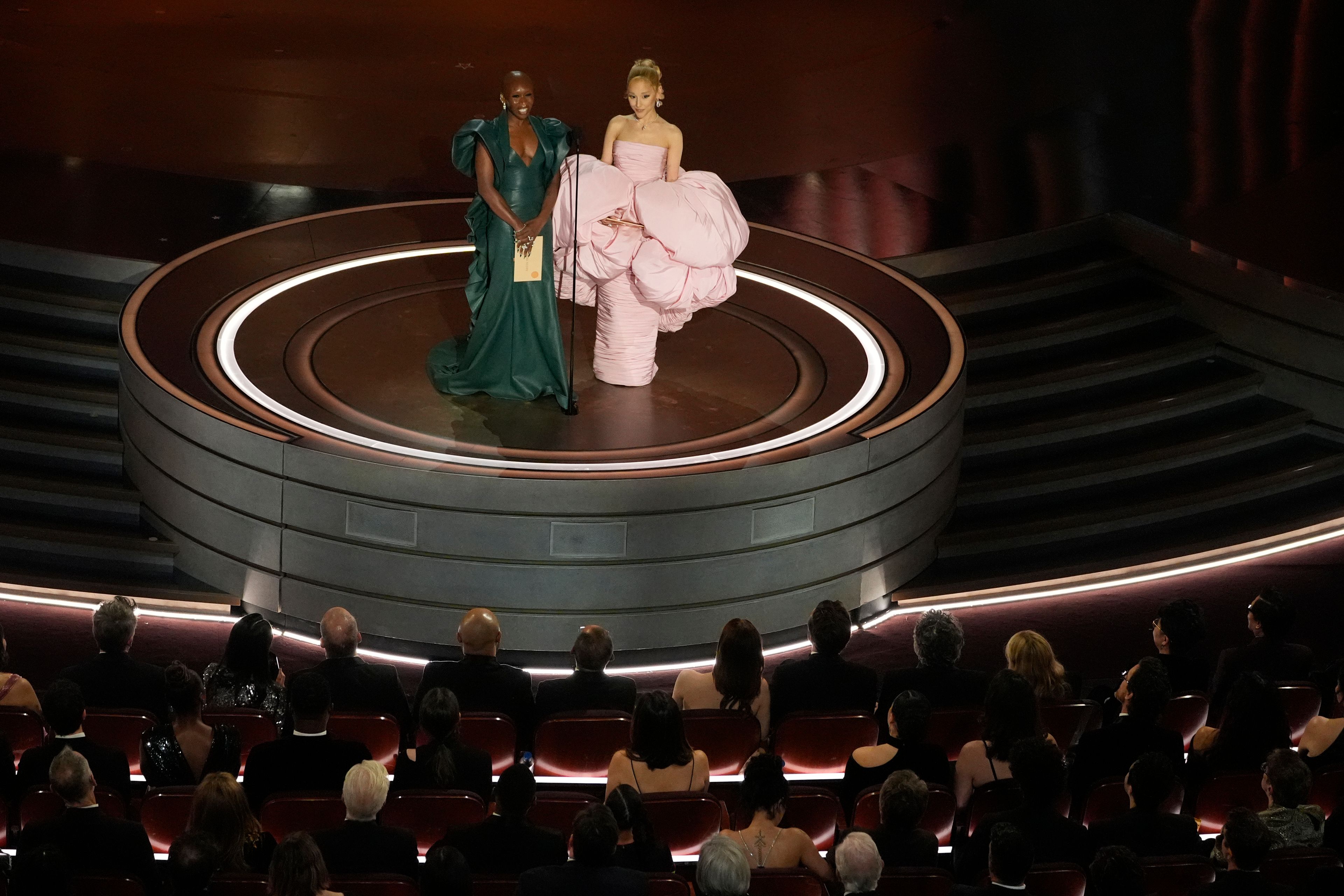 FILE - Cynthia Erivo, left, and Ariana Grande presents the award for best original score during the Oscars on Sunday, March 10, 2024, at the Dolby Theatre in Los Angeles. In “Wicked,” Elphaba and Glinda travel from Shiz University to the Emerald City on a glistening green train to meet the wizard. In real life, Cynthia Erivo and Ariana Grande have traveled much farther and wider and longer and on airplanes to promote their hotly anticipated film. (AP Photo/Chris Pizzello, File)