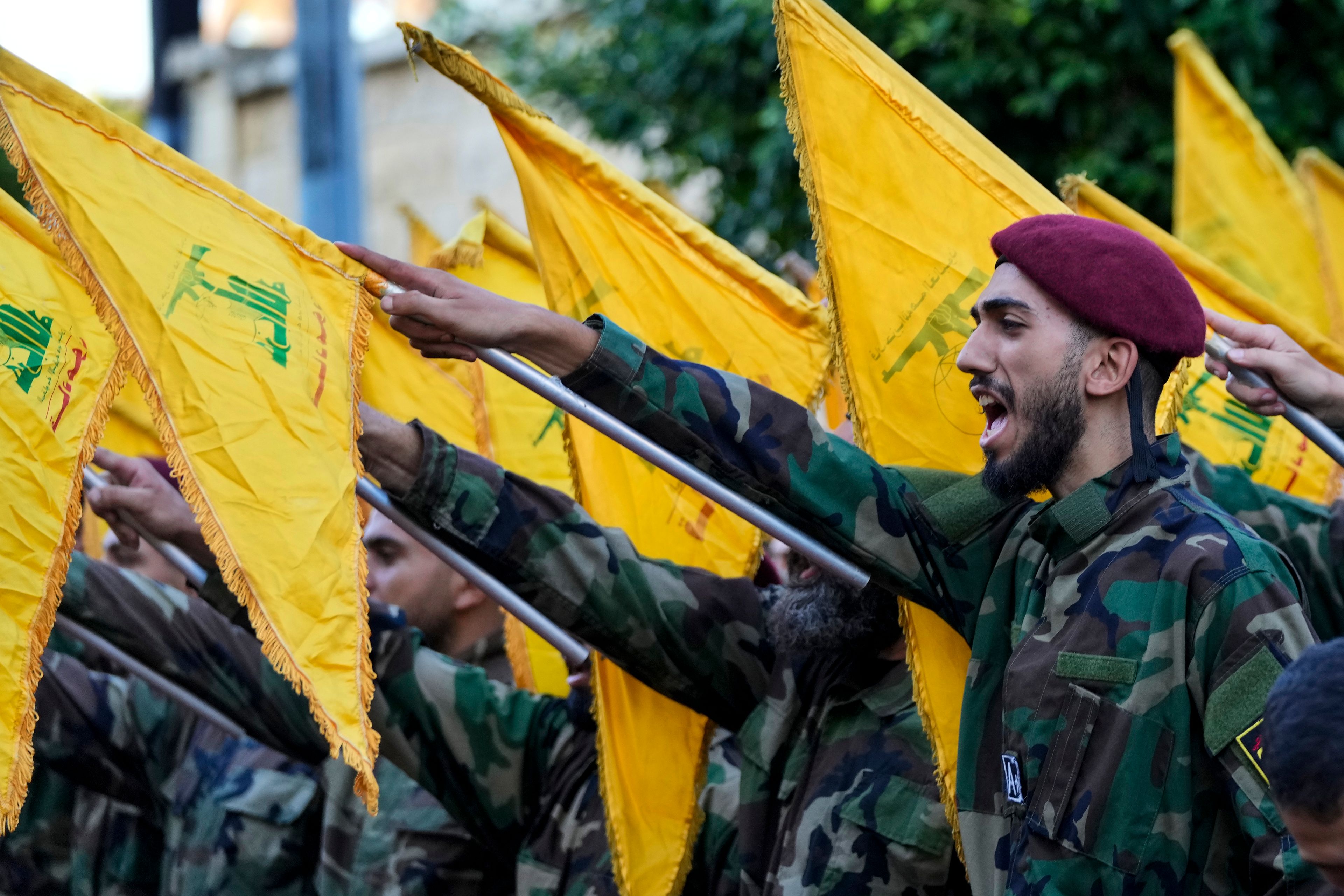 Hezbollah members raise their group flags and chant slogans as they attend the funeral procession of Hezbollah commanders Ibrahim Kobeisi and Hussein Ezzedine in Beirut's southern suburb, Wednesday, Sept. 25, 2024. (AP Photo/Hassan Ammar)