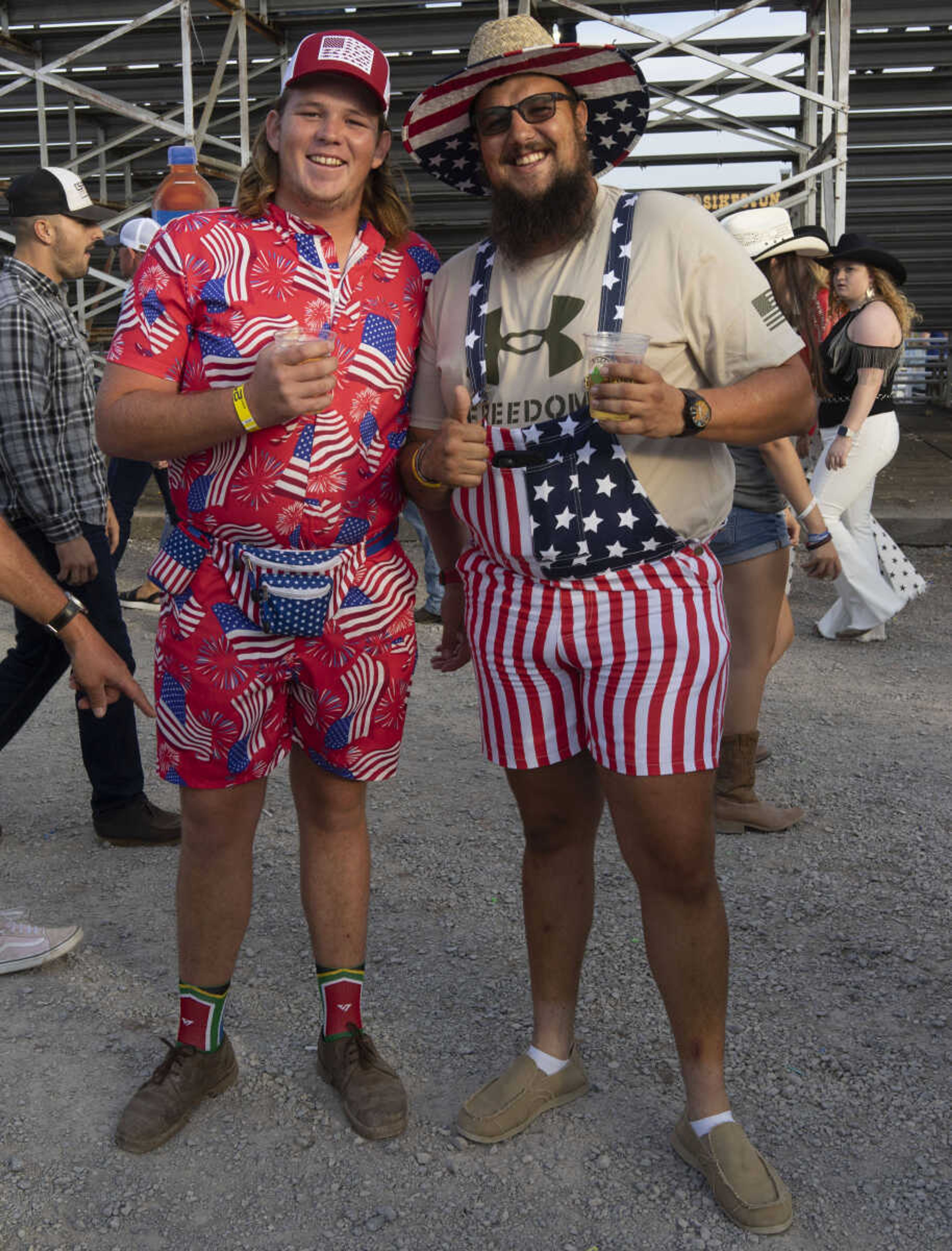 Abrie Venter, left and Peter Visser, both of South Africa, smile for a portrait in elaborate stars-and-stripes attire during the last night of the Sikeston Jaycee Bootheel Rodeo Saturday, Aug. 14, 2021. The pair, who attended the rodeo with a larger group of their South African colleagues, work in agriculture around the Missouri bootheel on farming visas and were proud to be attending their third Bootheel Rodeo&nbsp;in Sikeston, Missouri.