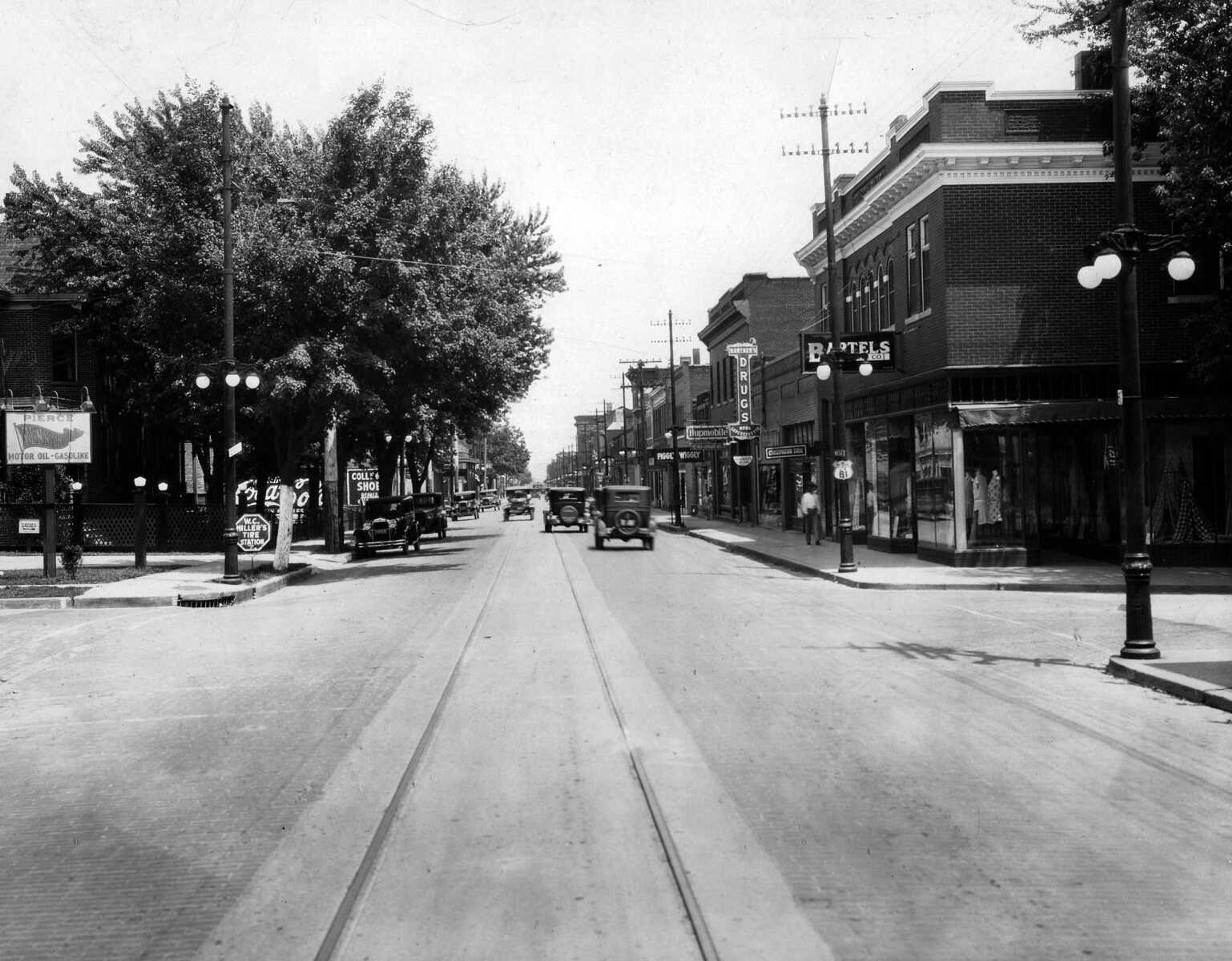 By the late 1920s when this photo was made, the south side of Broadway at Ellis had become crowded with commercial buildings. The Drusch building then housed the Bartels Store. East of the corner building is the Conservation Store, Hartner's Drug Store and Luncheonette, the Hupmobile auto agency, and Piggly Wiggly.