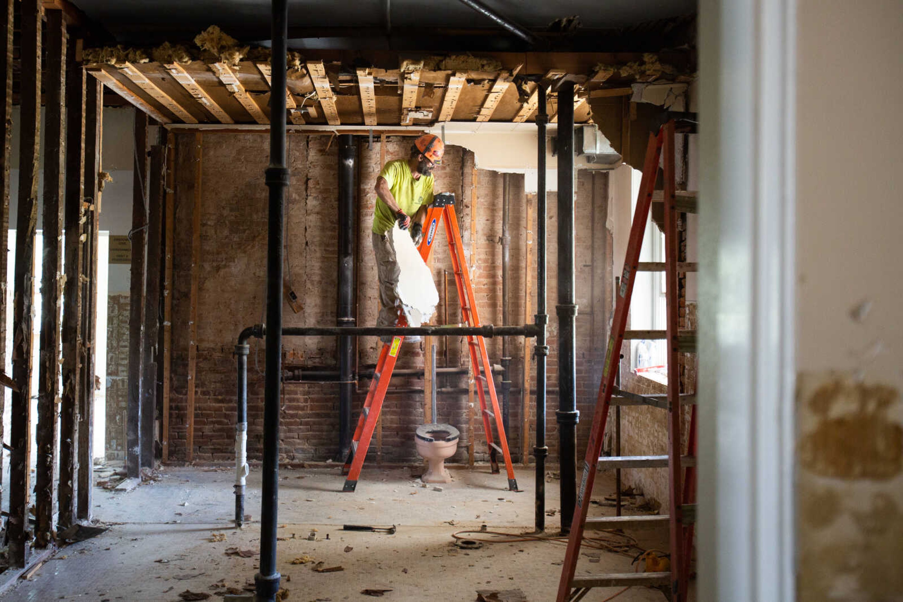 Ray Duncan pries up pieces of drywall, exposing studs and the original brick wall of the Common Pleas Courthouse as crews from Penzel Construction continue the demolition phase of the historic building's renovation on Tuesday, June 16, 2020.