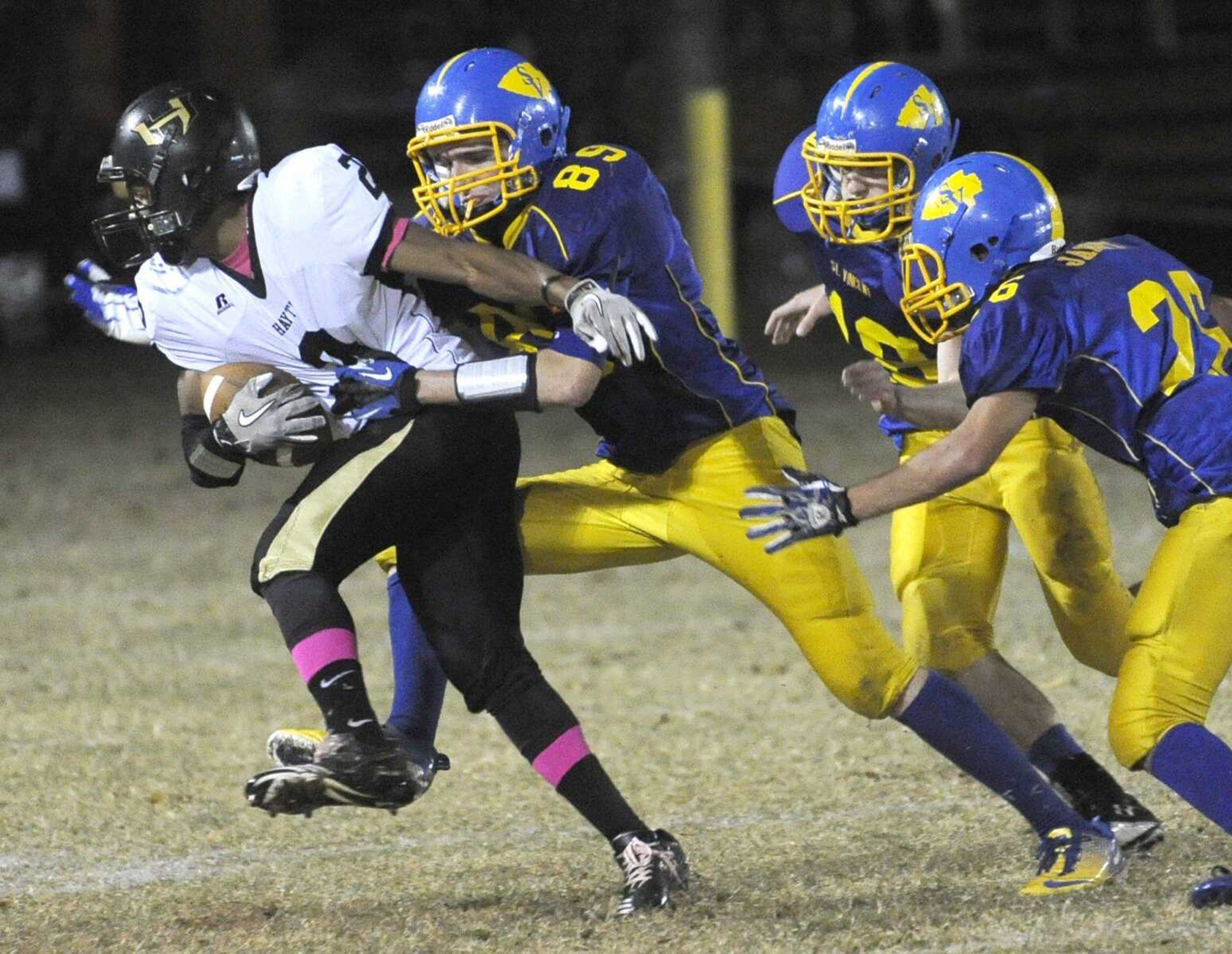 Hayti&#8217;s Maurion Newbill tries to break away from St. Vincent defenders Trenton Gremaud, left, Zac Heberlie and Lucas Janet during the second quarter of their Class 1 District 1 first-round game Thursday in Perryville, Mo. (Fred Lynch)