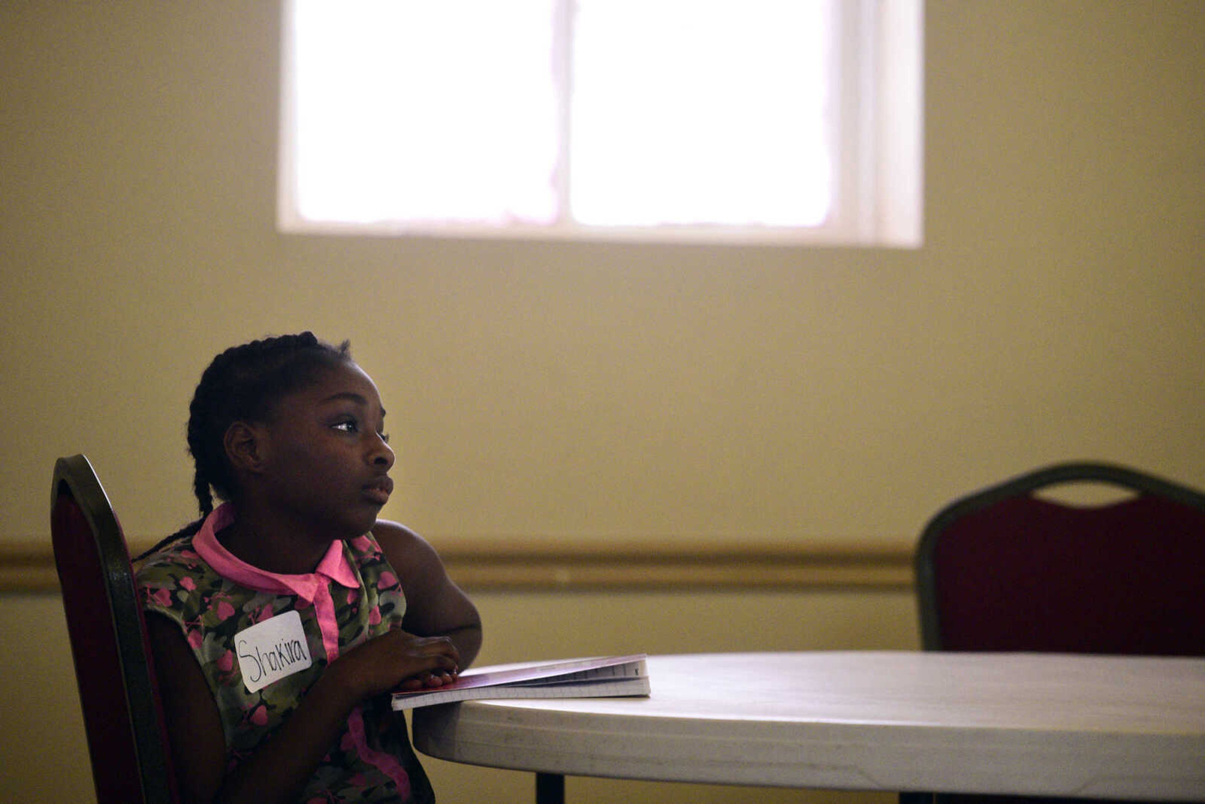 Shakira Jones looks up from her journal on Monday, Aug. 14, 2017, during the Salvation Army's after school program at The Bridge Outreach Center in Cape Girardeau.