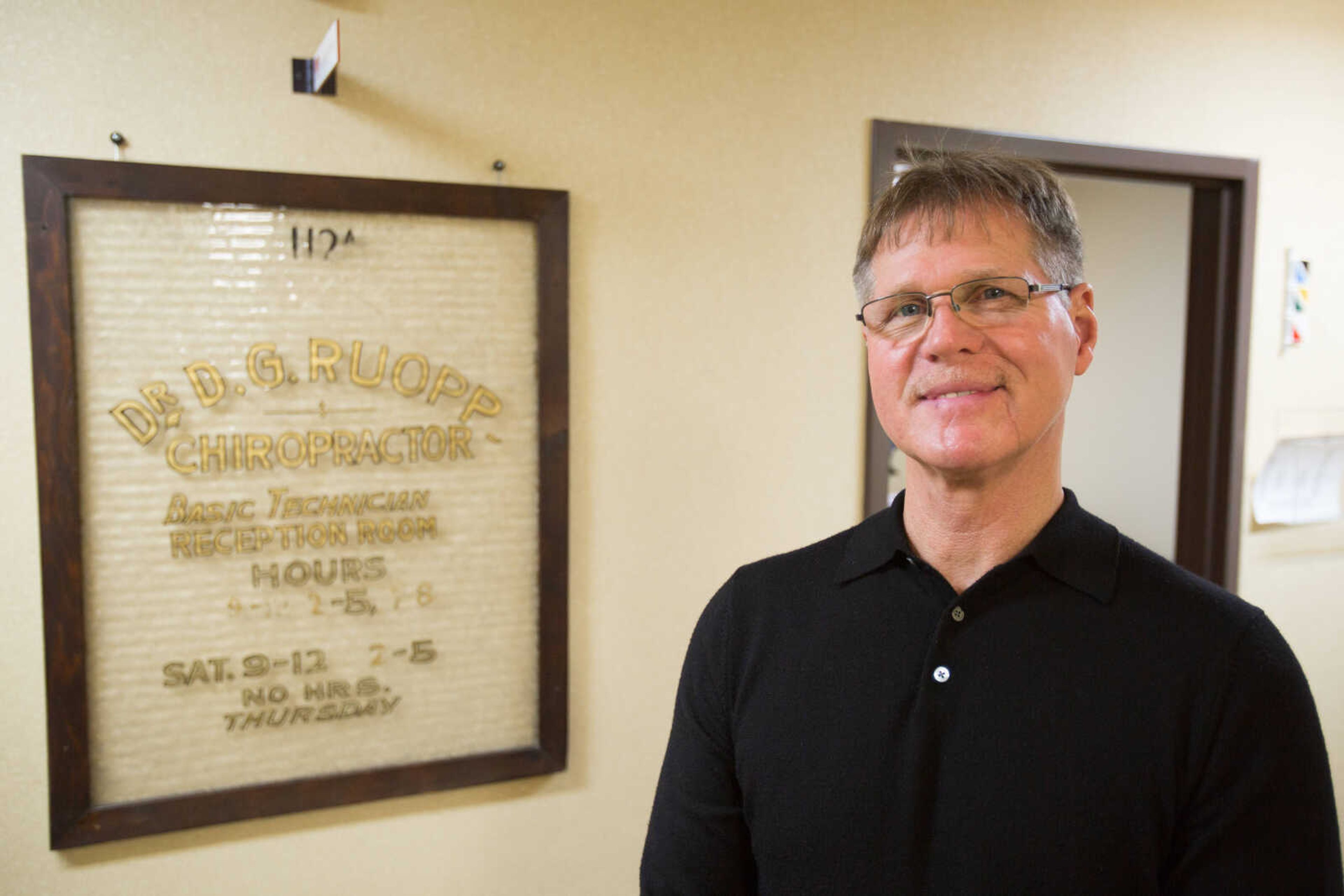 Dr. Jack Ruopp of Hudson Chiropractic stands near a window that once hung in his father's chiropractic practice.