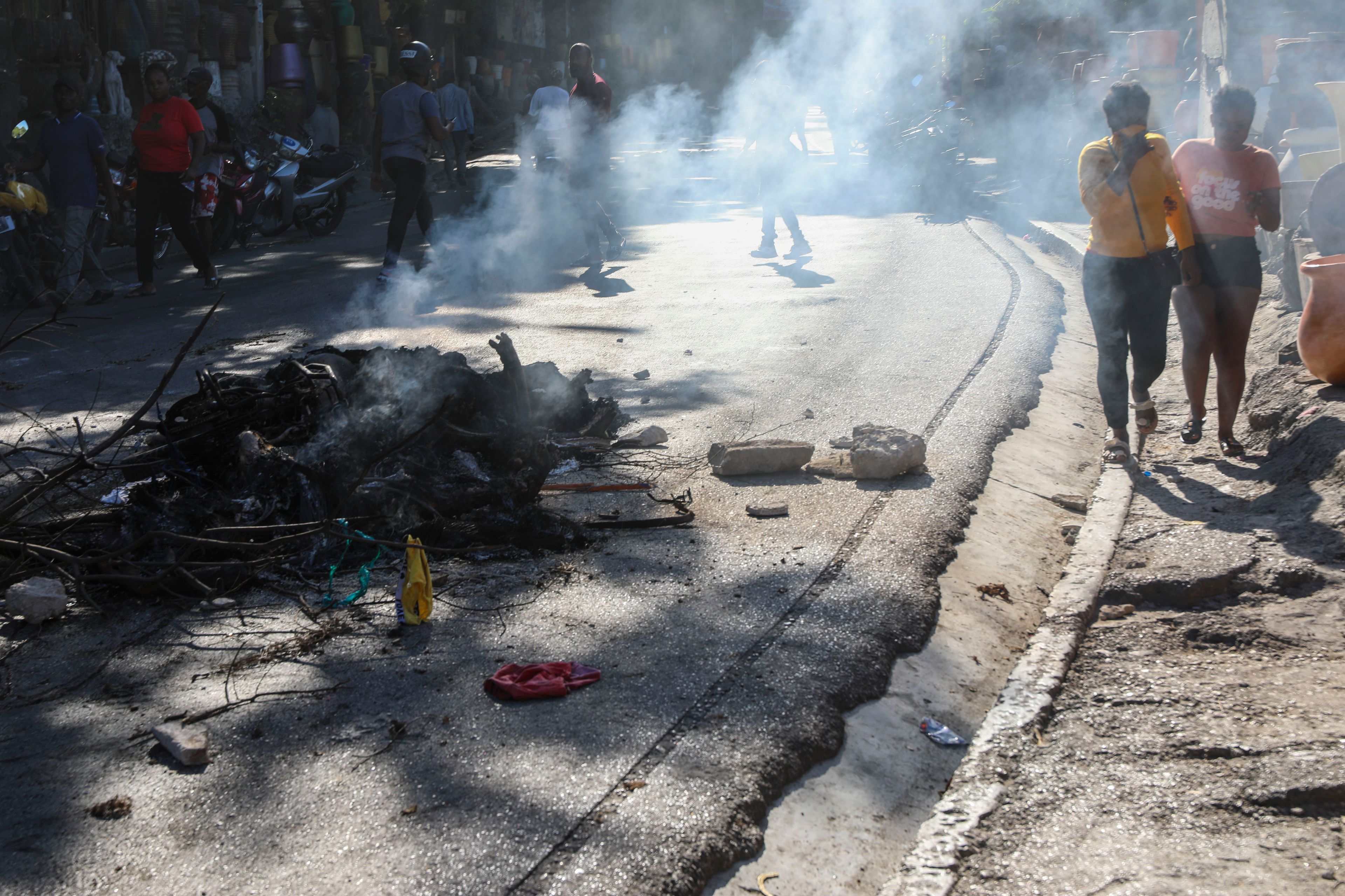 The bodies of suspected gang members who were set on fire by residents, sit in a pile in the middle of a road in the Pétion-Ville neighborhood of Port-au-Prince, Haiti, Tuesday, Nov. 19, 2024. (AP Photo/Odelyn Joseph)