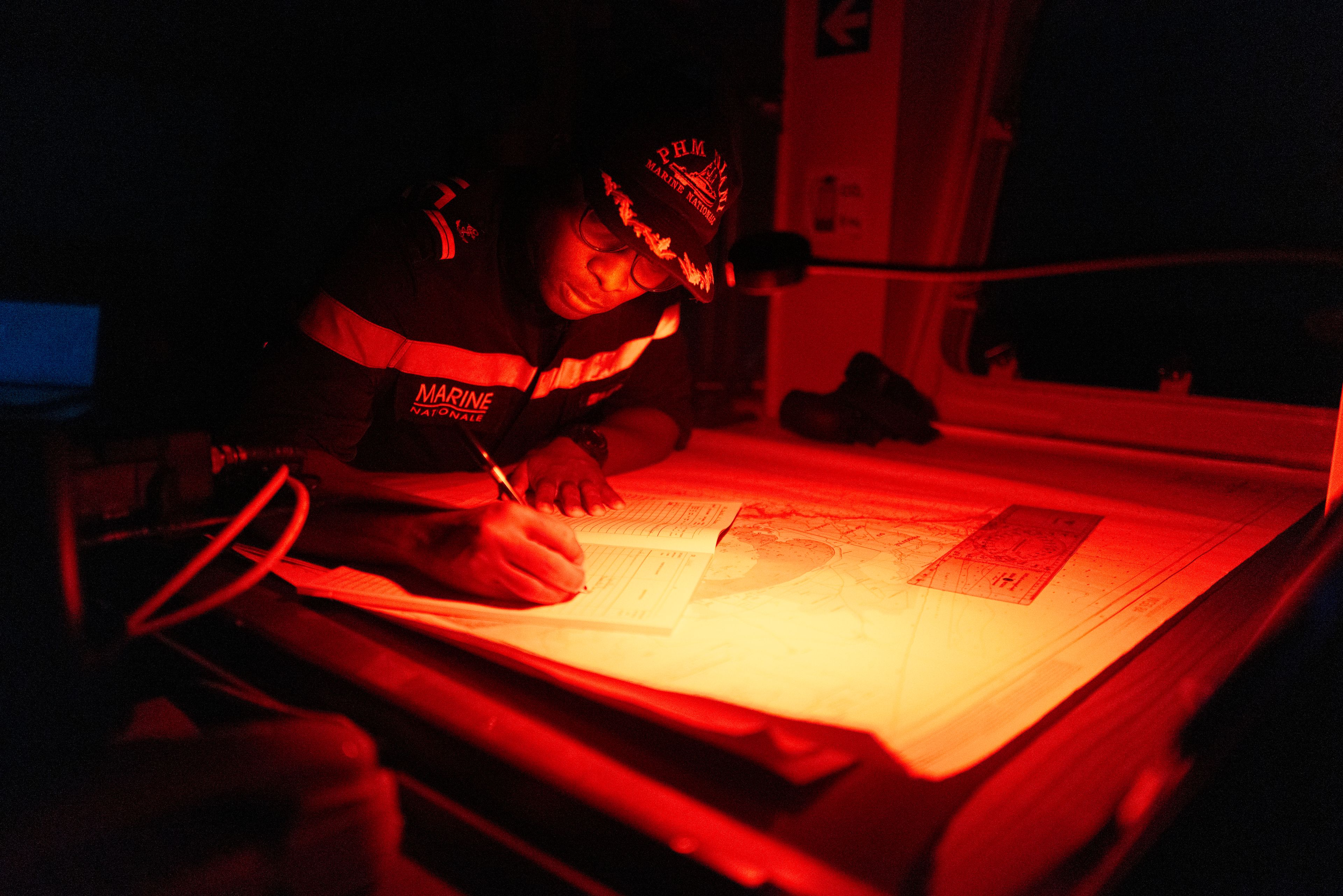 A Senegalese sailor fills in the logbook of the offshore patrol vessel Niani during a mission to search for illegal migrant boats near the coast of Dakar, Senegal, Saturday, Nov.16, 2024. (AP Photo/Sylvain Cherkaoui)