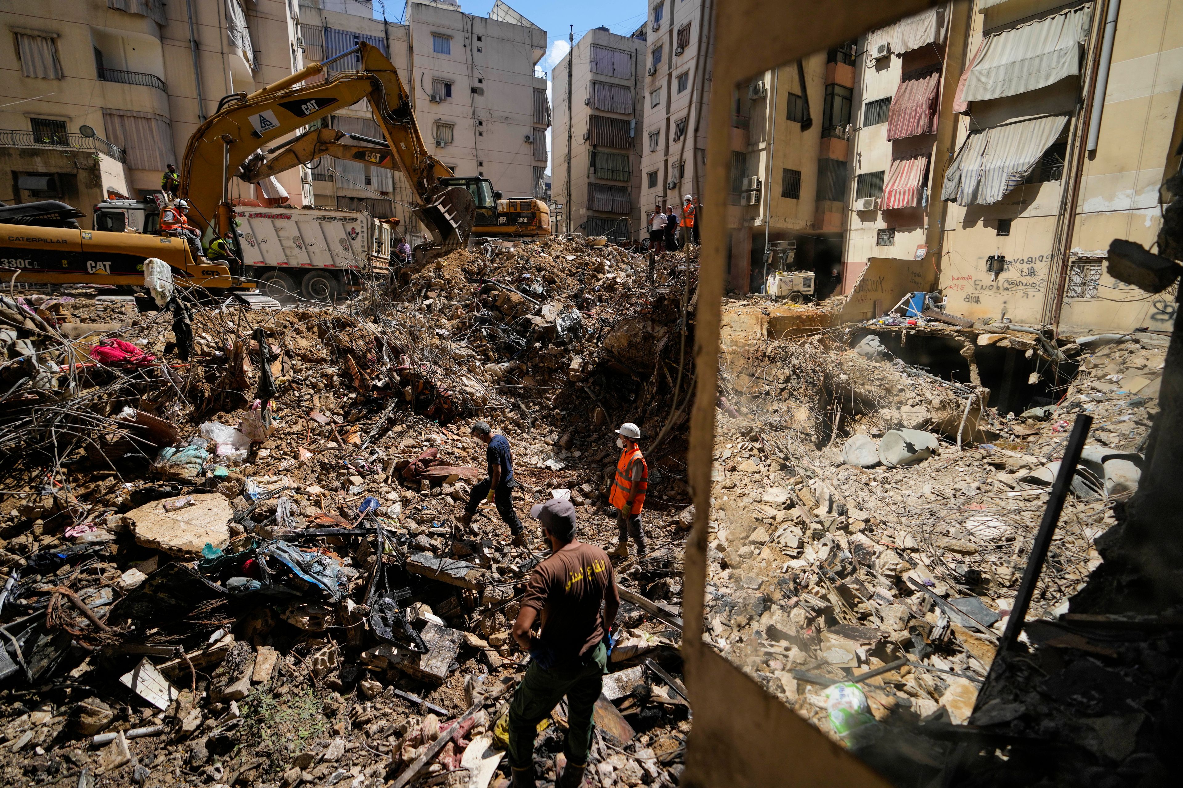 Emergency workers use excavators to clear the rubble at the site of Friday's Israeli strike in Beirut's southern suburbs, Lebanon, Monday, Sept. 23, 2024. (AP Photo/Hassan Ammar)