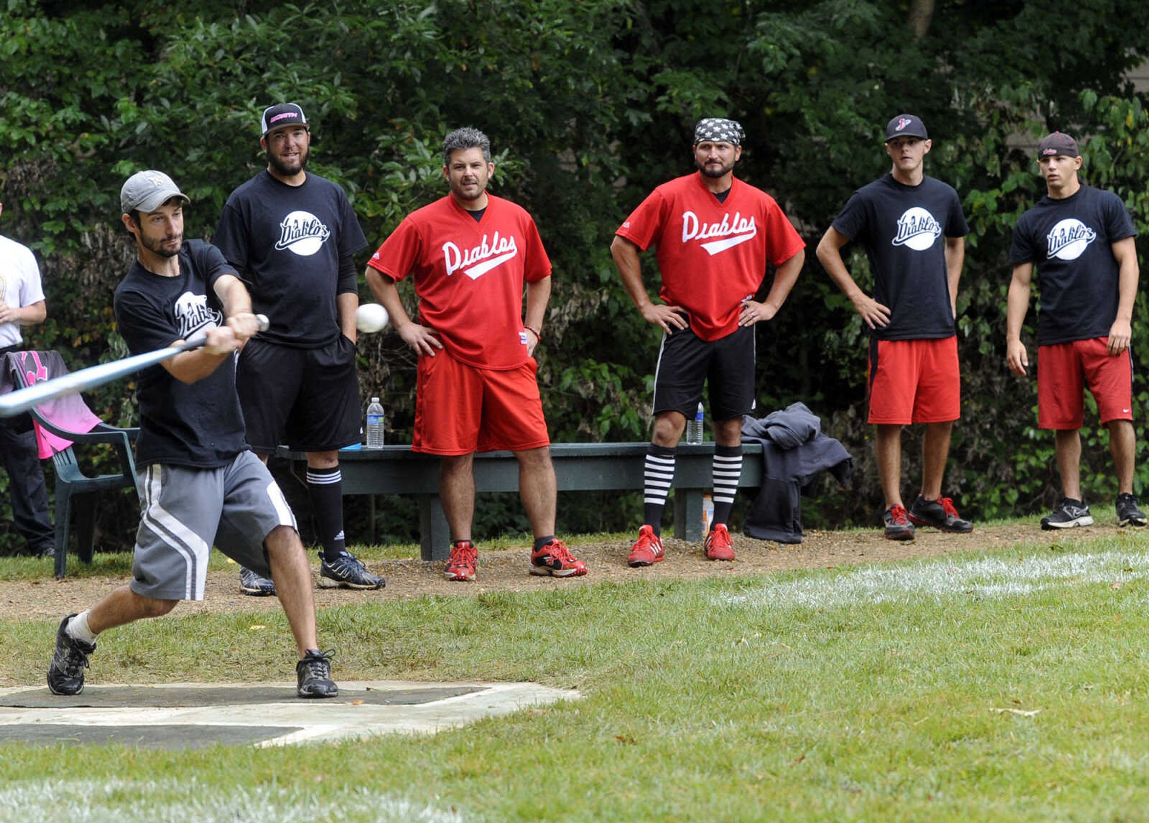 The Diablos' Nick Centanni swings at a pitch as teammates watch, from left, Jeff Beasley, Jeff Augustine, Shawn Roll Huston, Trent Wills and Steven Porzelt.