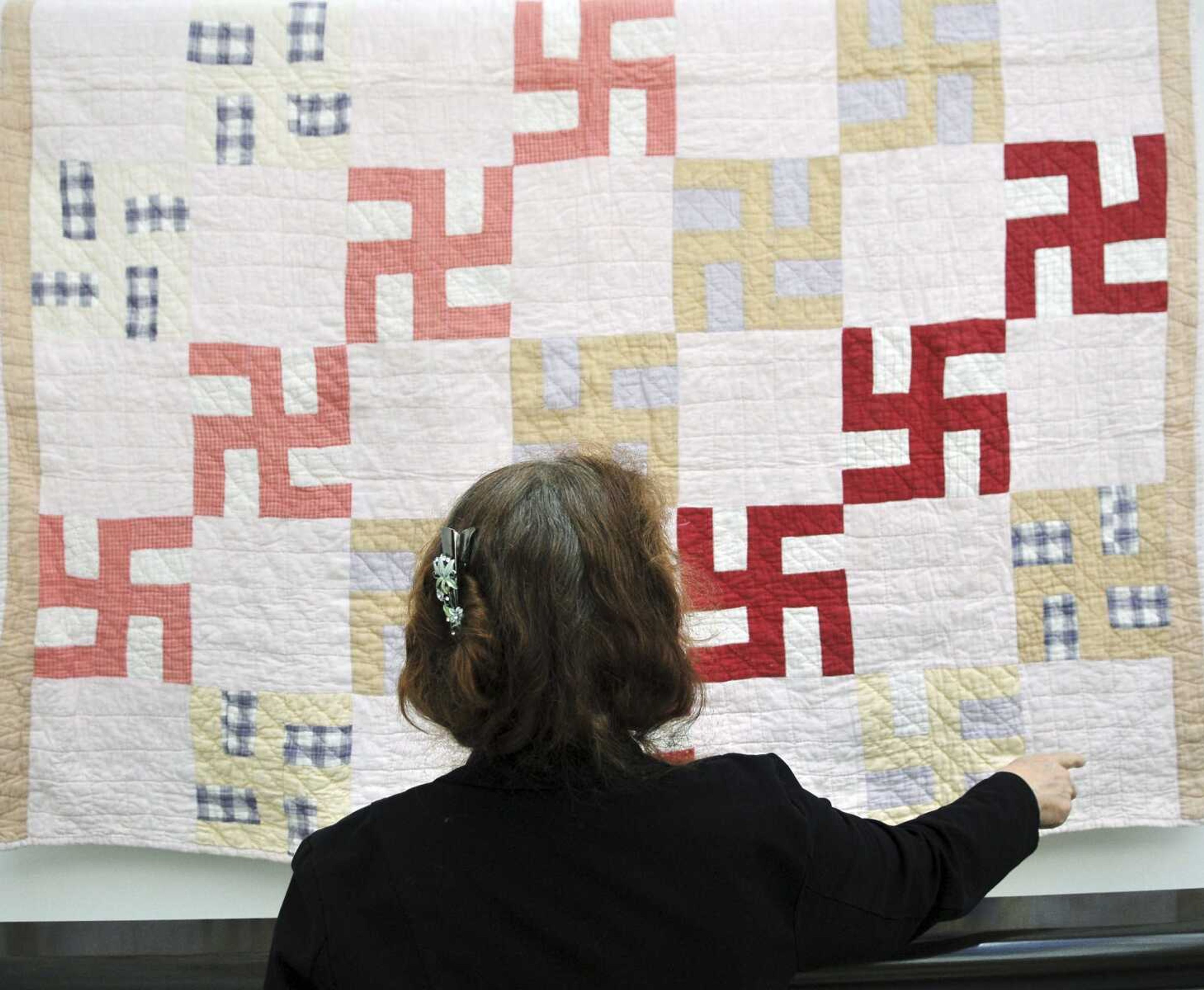 JoAnna Stull of the Greeley History Museum looks at a quilt decorated with swastikas June 18, 2010, in Greeley, Colorado. The quilt was probably made before 1930, according to the family and the Greeley Museums. Hitler adopted the symbol in 1935.