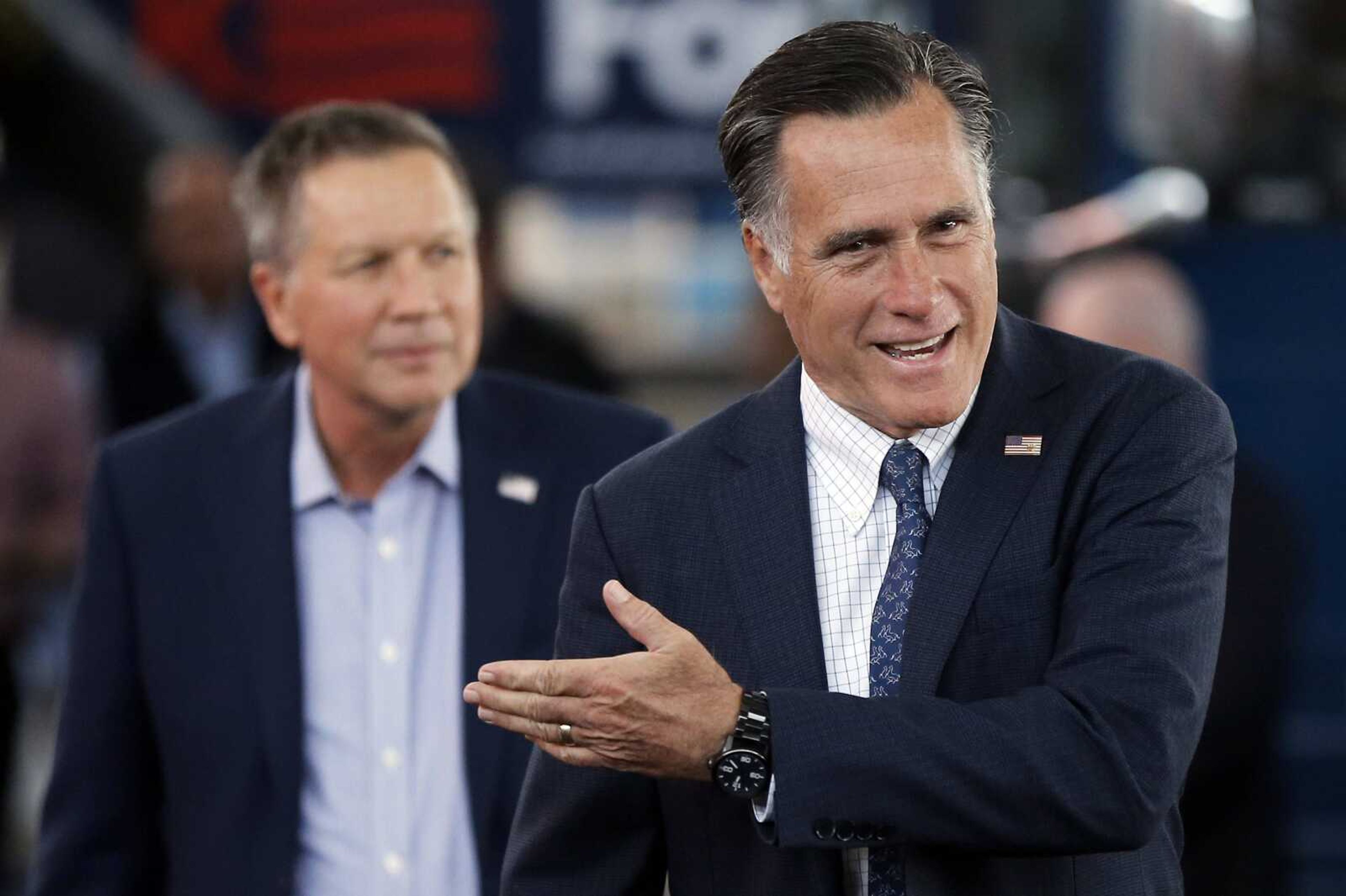 Republican presidential candidate John Kasich, left, accompanied by former Republican presidential candidate Mitt Romney, arrive for a campaign stop Monday at the MAPS Air Museum in North Canton, Ohio.