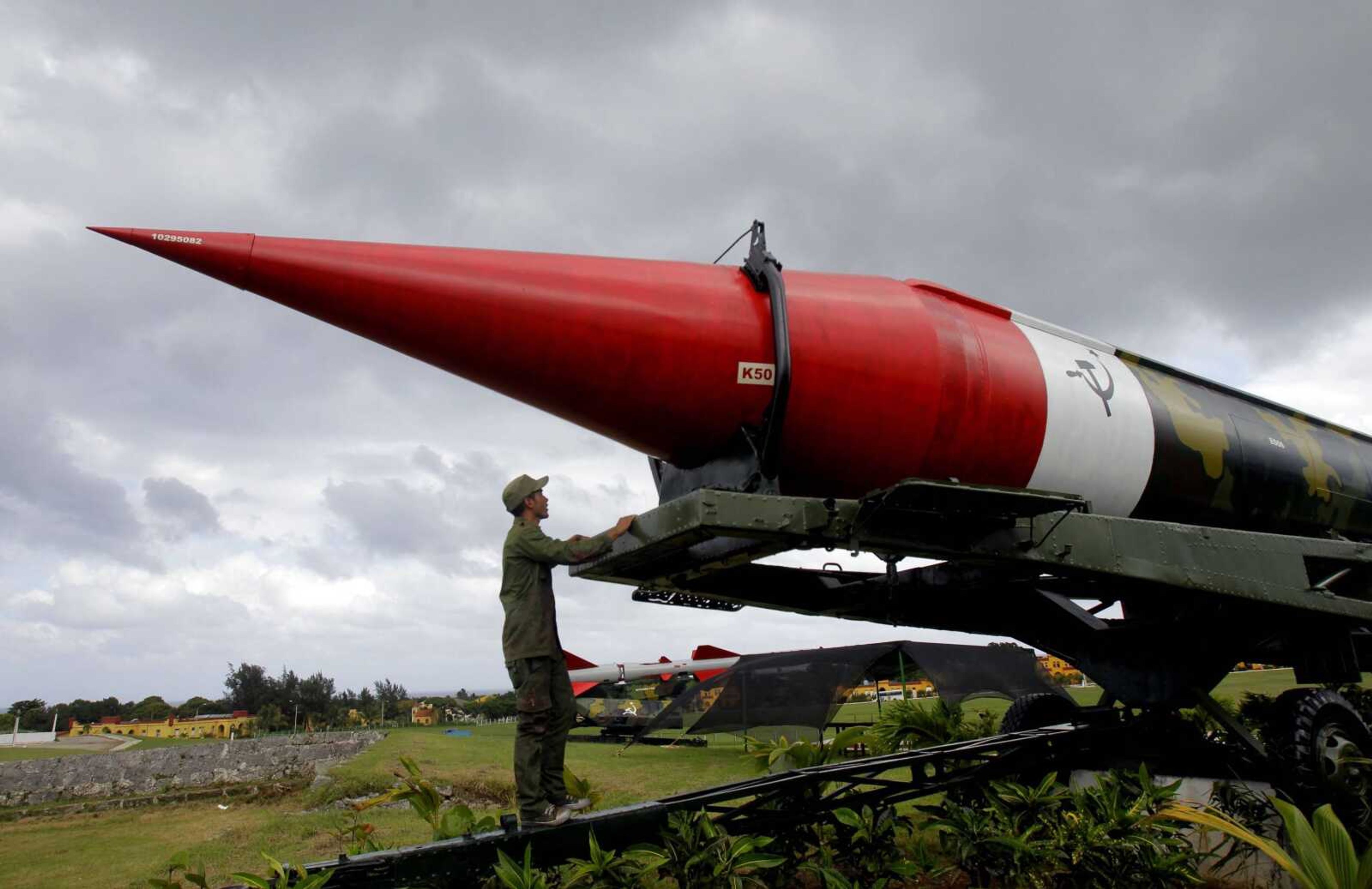 A soldier paused to look at the outer casing of an old empty Soviet missile on exhibit as he worked to paint it at the military complex Morro Cabana which is open to tourists in Havana, Cuba. The world stood at the brink of Armageddon for 13 days in October 1962, when President John F. Kennedy drew a symbolic line in the Atlantic and warned of dire consequences if Soviet Premier Nikita Khrushchev dared to cross it. On the eve of the 50th anniversary of the Cuban missile crisis, historians now say it was behind-the-scenes compromise rather than a high-stakes game of chicken that resolved the faceoff, that both Washington and Moscow wound up winners and that the crisis lasted far longer than 13 days. (AP Photo/Ismael Francisco, Cubadebate)