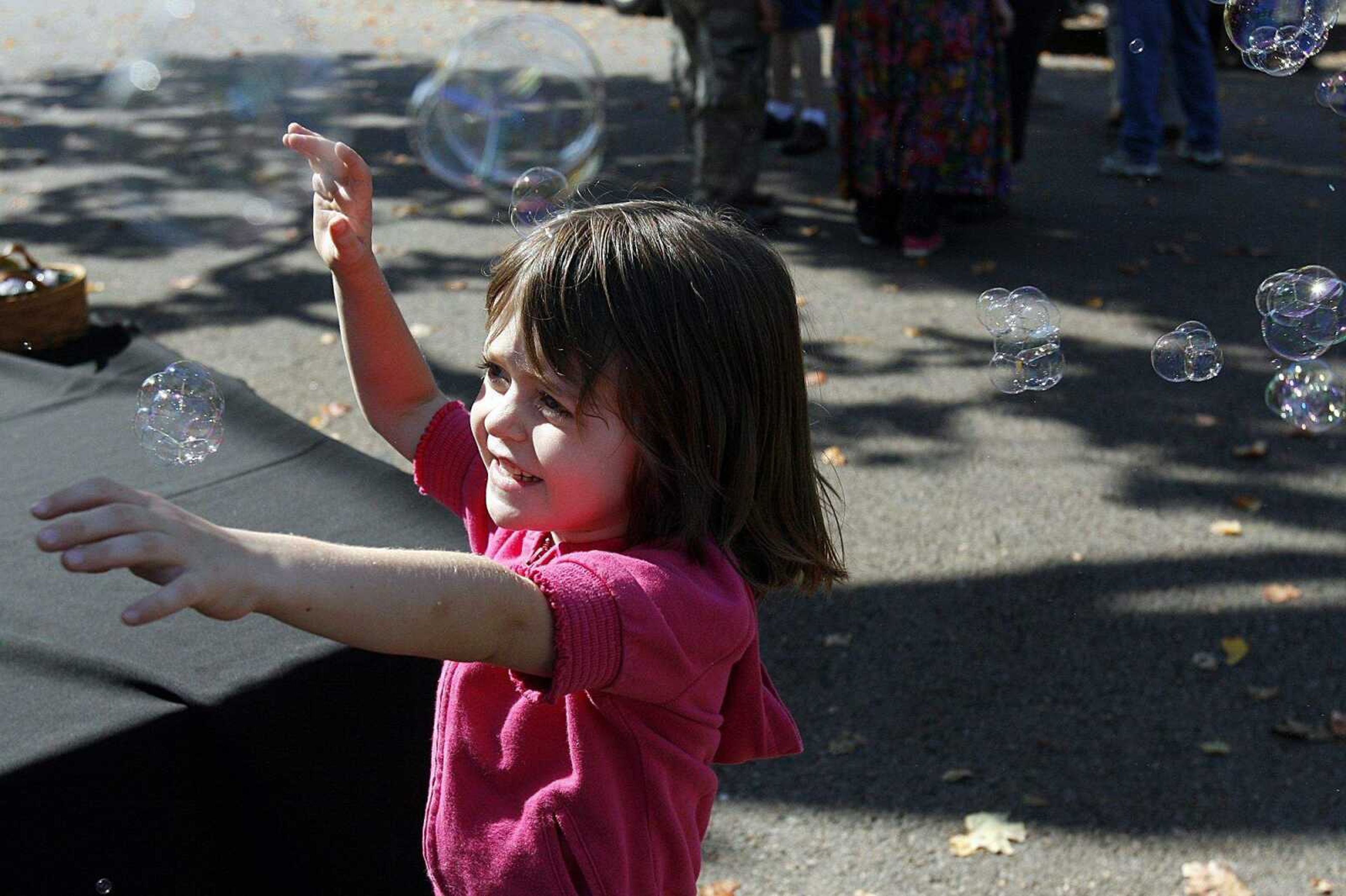 ELIZABETH DODD ~ edodd@semissourian.com
Claire Southard, 5, of Cape Girardeau, tries to catch bubbles at the Neighborhood Connections Block Party on Fountain Street in Cape Girardeau Saturday.