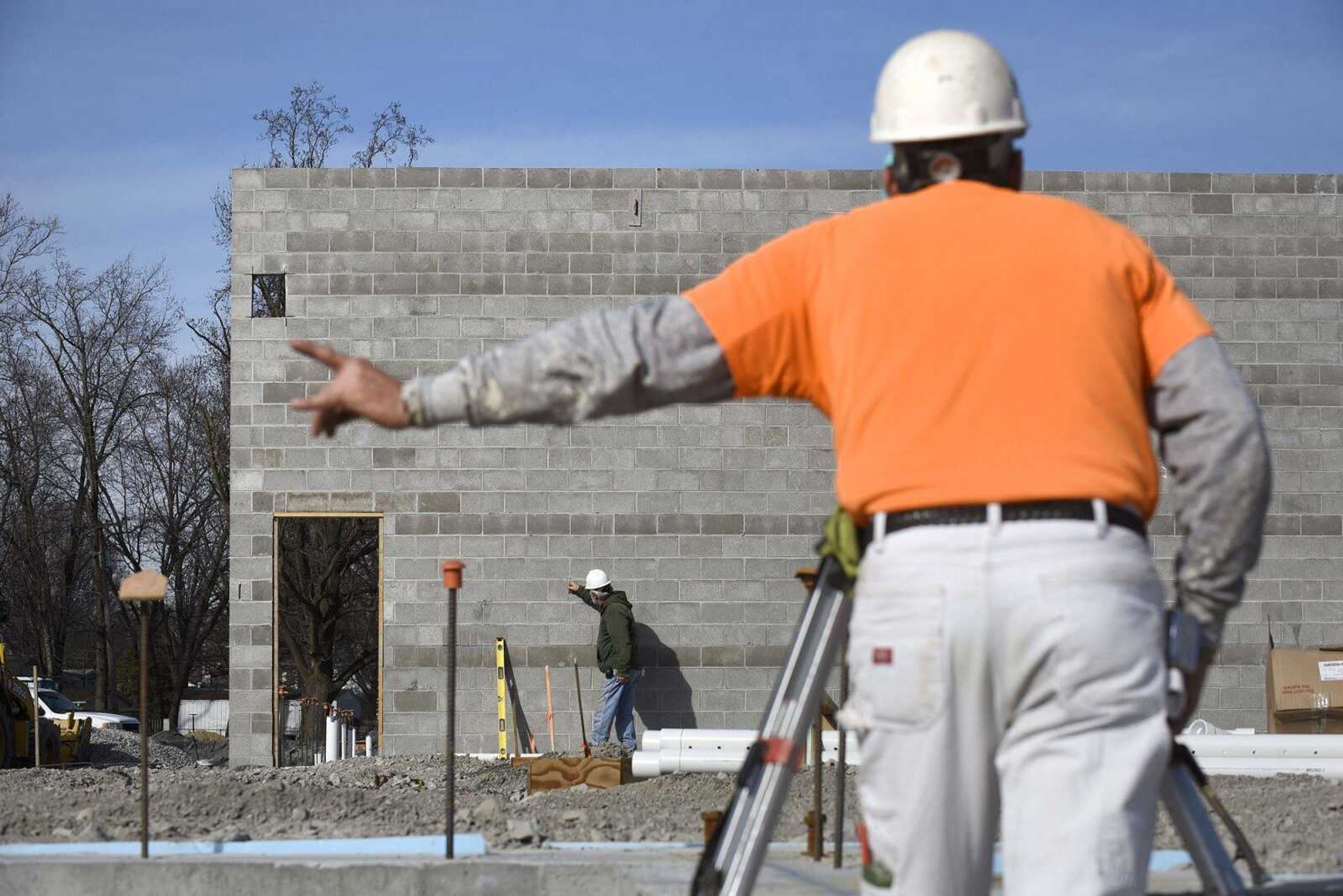 Chris Heisserer directs his coworker, Mike Glastetter, both with Kiefner Brothers Inc., as to where to mark the wall while setting center lines for steel erection at the site Friday of the new Cape Girardeau Police Department station.