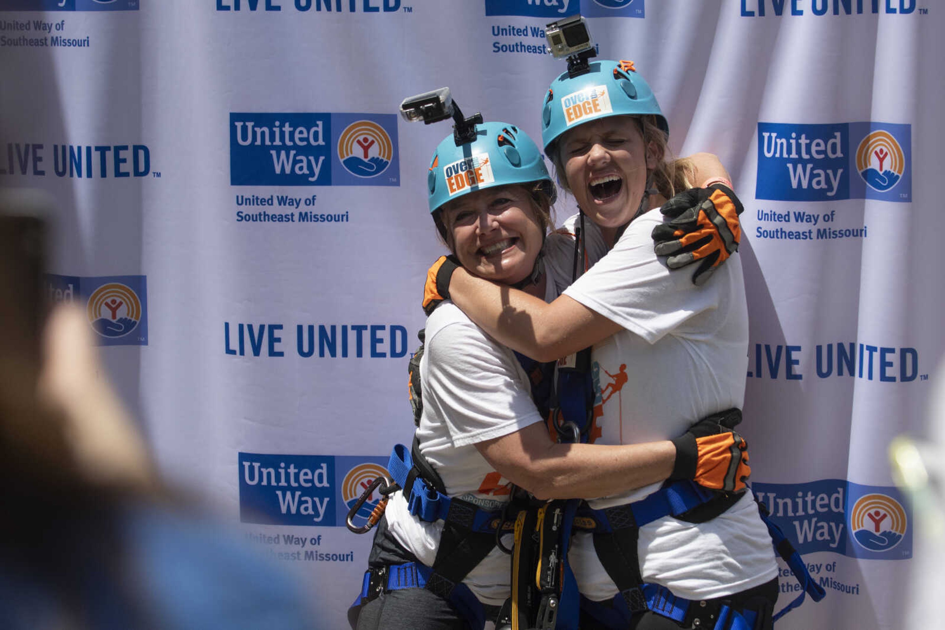 Elizabeth Shelton, executive director of United Way of Southeast Missouri, left, and Raechel Reinitz, community relations manager for the United Way of Southeast Missouri, have pictures made shortly after rappelling down the side of Southeast Missouri State University's Towers South dormitory during the United Way of Southeast Missouri's Over the Edge fundraising event Friday, May 17, 2019, in Cape Girardeau.