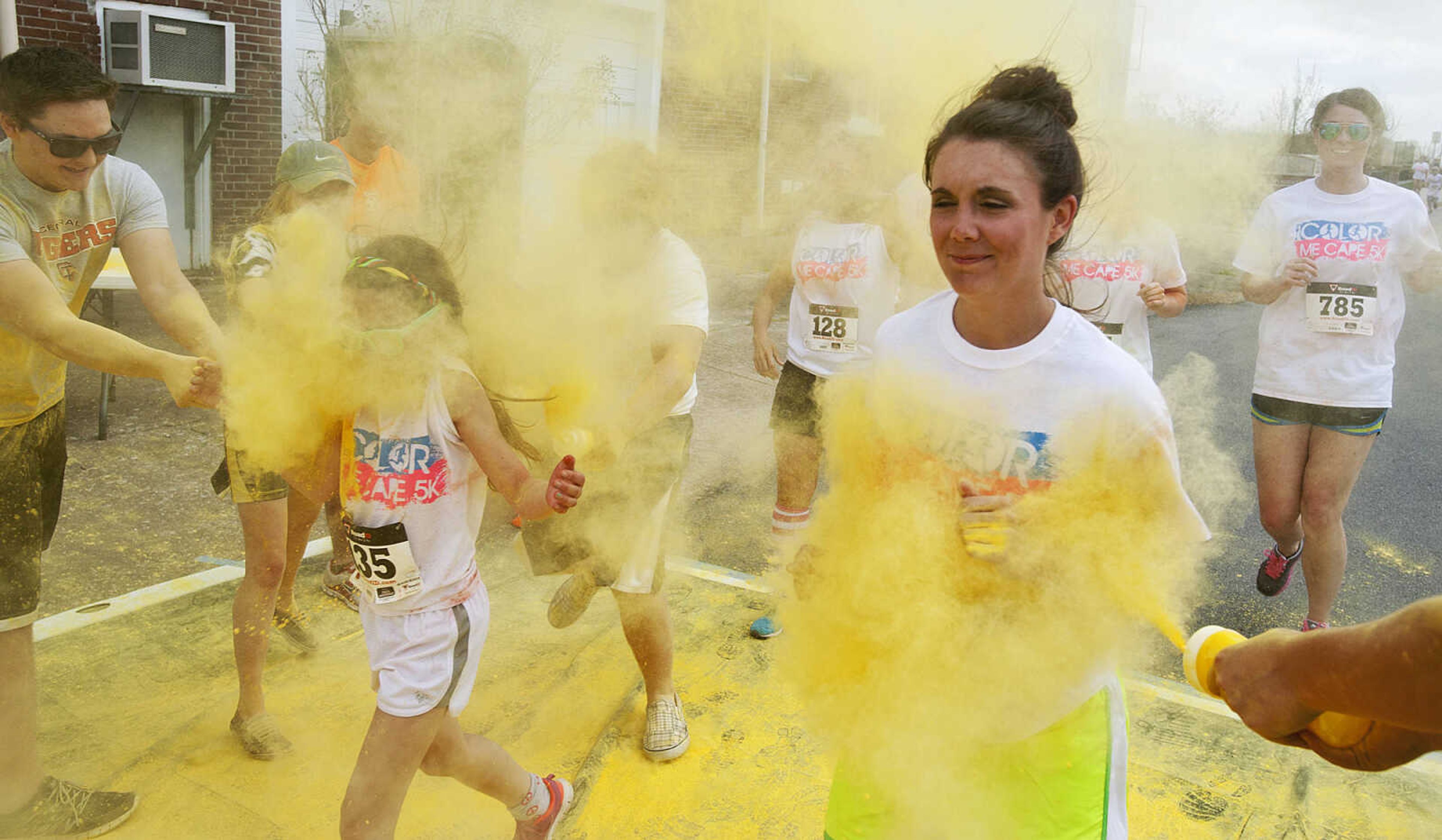 ADAM VOGLER ~ avogler@semissourian.com
Participants in the Color Me Cape 5k run through the yellow color station north of the intersection of Independence Street and Frederick Street Saturday, April 12, in Cape Girardeau.