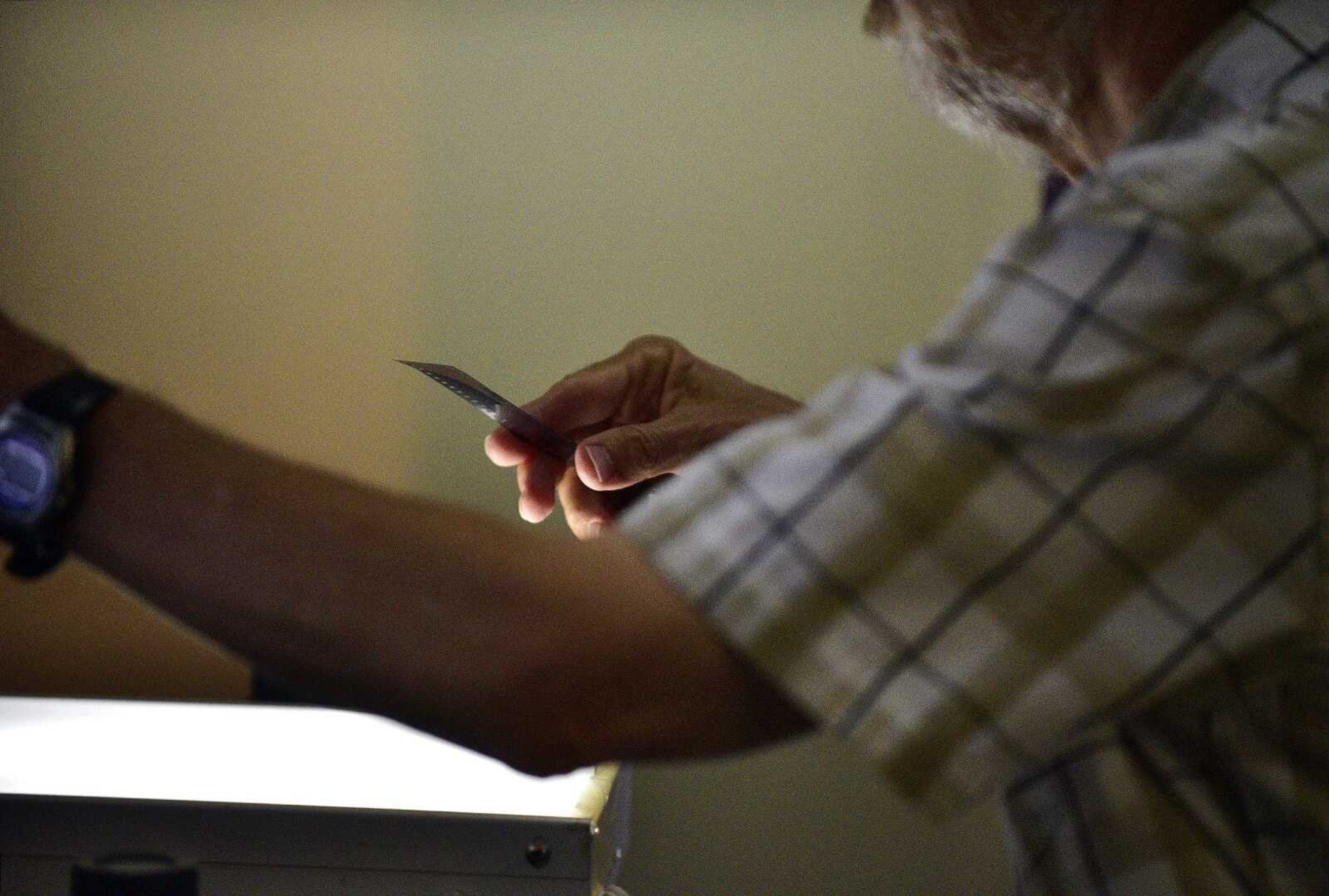 Southeast Missourian photojournalist, Fred Lynch, looks through a sleeve of old black and white negatives in the photo office on Friday, June 9, 2017.