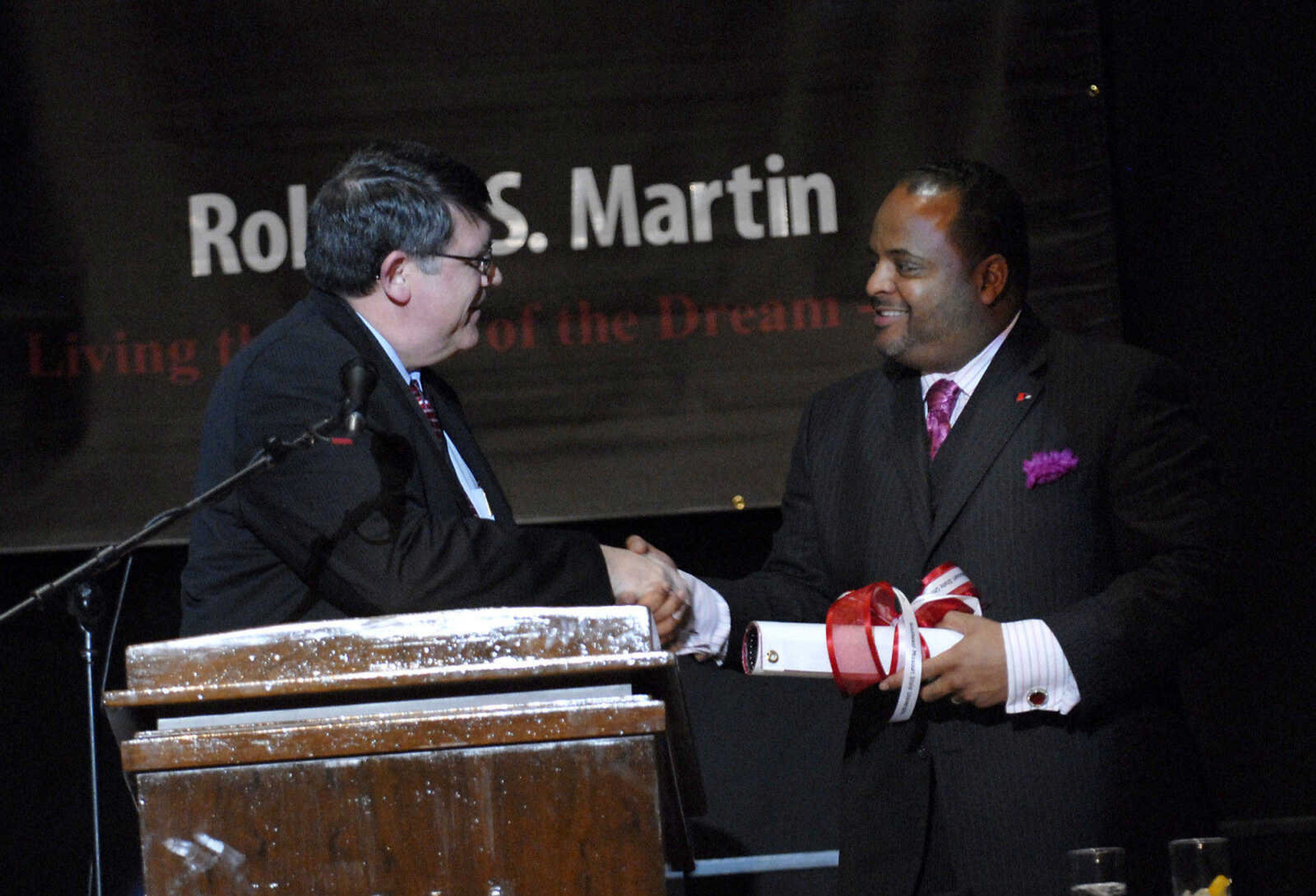 KRISTIN EBERTS ~ keberts@semissourian.com

Southeast Missouri State University President Kenneth Dobbins, left, presents Keynote Speaker Roland Martin with a banner during the "Living the Spirit of the Dream" 2011 Dr. Martin Luther King, Jr. Celebration Dinner at the Show Me Center on Wednesday, Jan. 19.