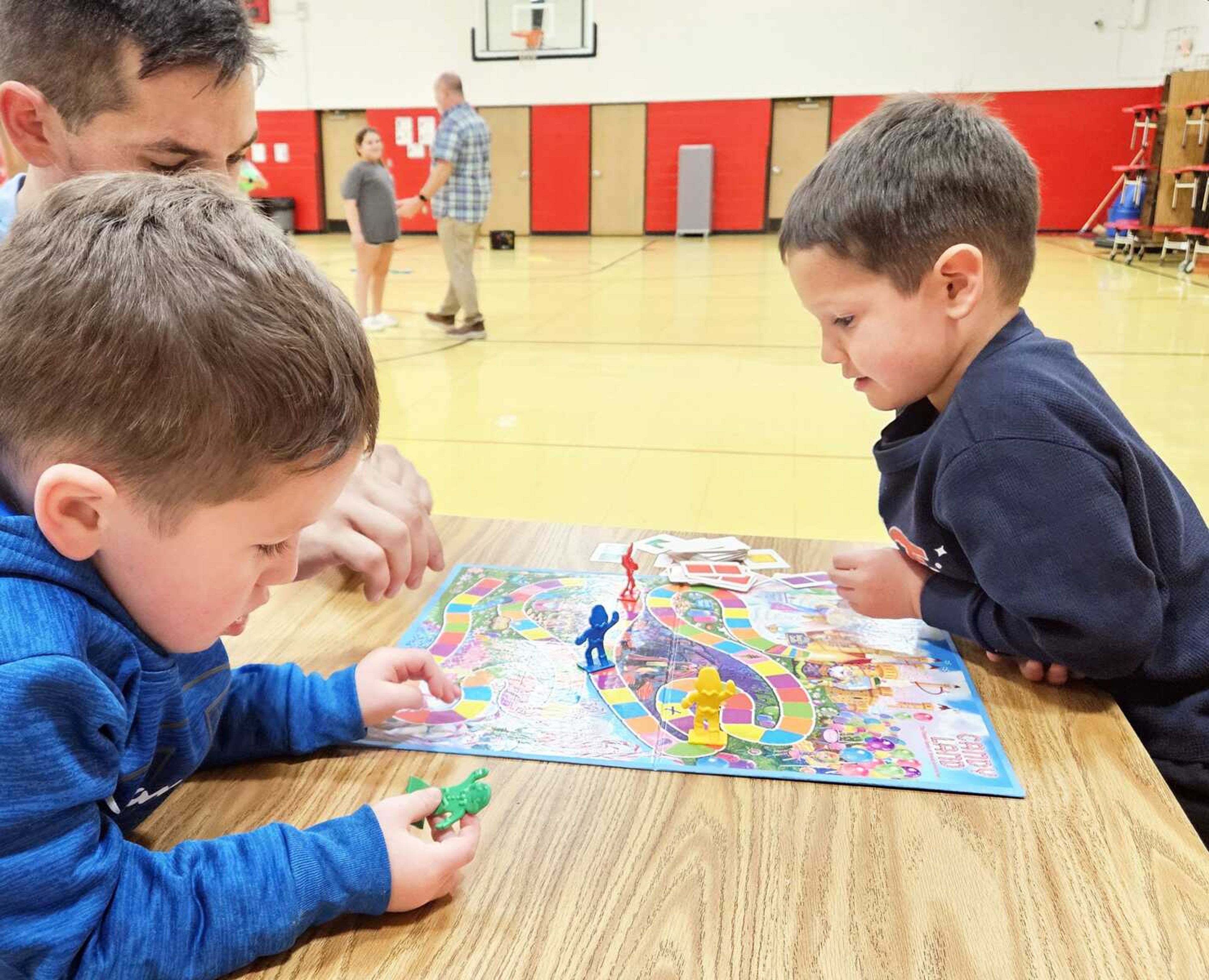 Families drop off their kids in the gym during parents' night before heading to various booths designed to answer parents' questions.