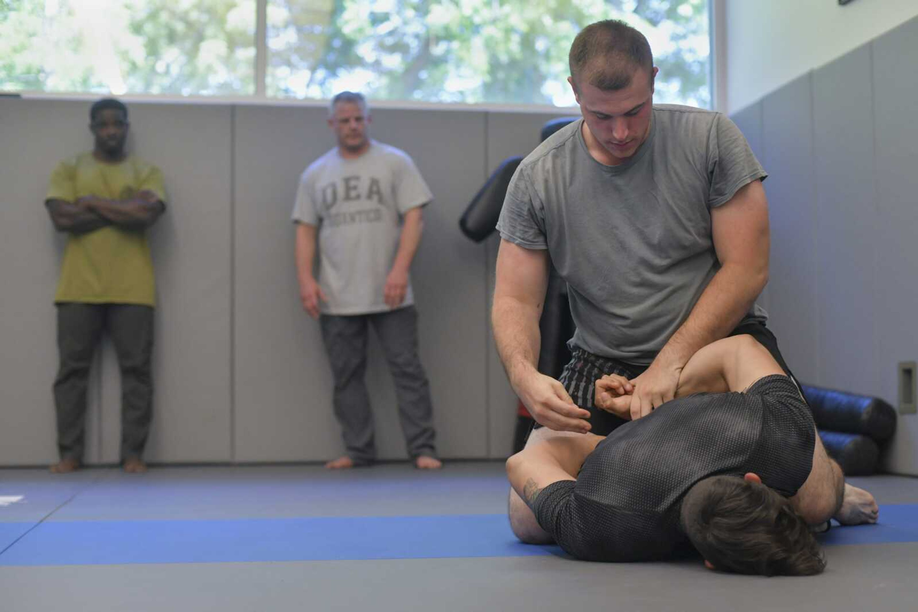 From left, Gracie Jiu-Jitsu of Southeast Missouri student Cantrell Andrews and professor Brian Imholz watch as Cape Girardeau police patrolman Jacob Monteith practices a de-escalation technique on Sgt. Joey Hann during a free training session Wednesday at the Cape Girardeau Police Department in Cape Girardeau.